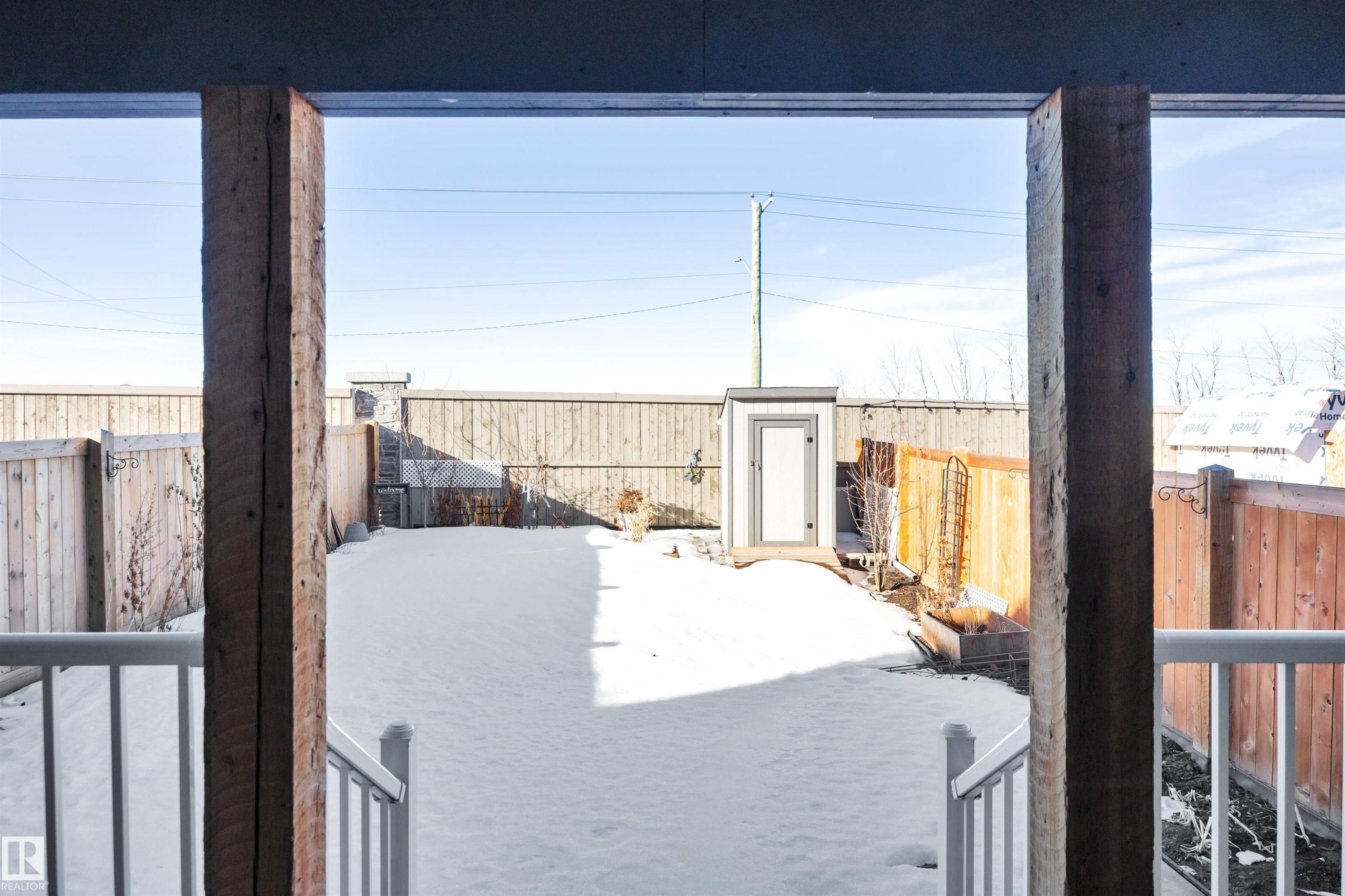 Yard covered in snow featuring a fenced backyard - 157 Larch Crescent, Leduc, AB - Outdoor With Exterior