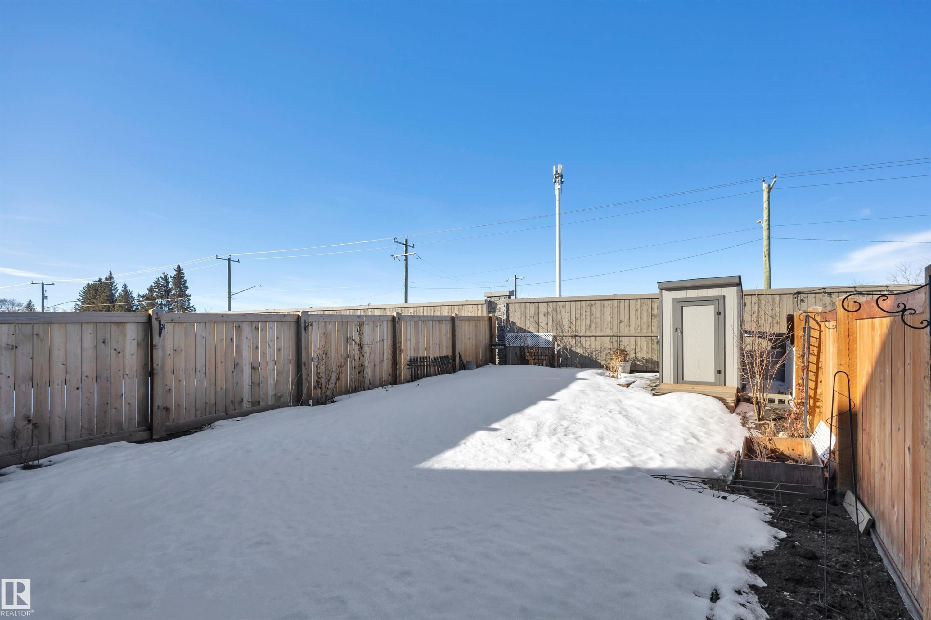 Yard layered in snow with a fenced backyard - 157 Larch Crescent, Leduc, AB - Outdoor