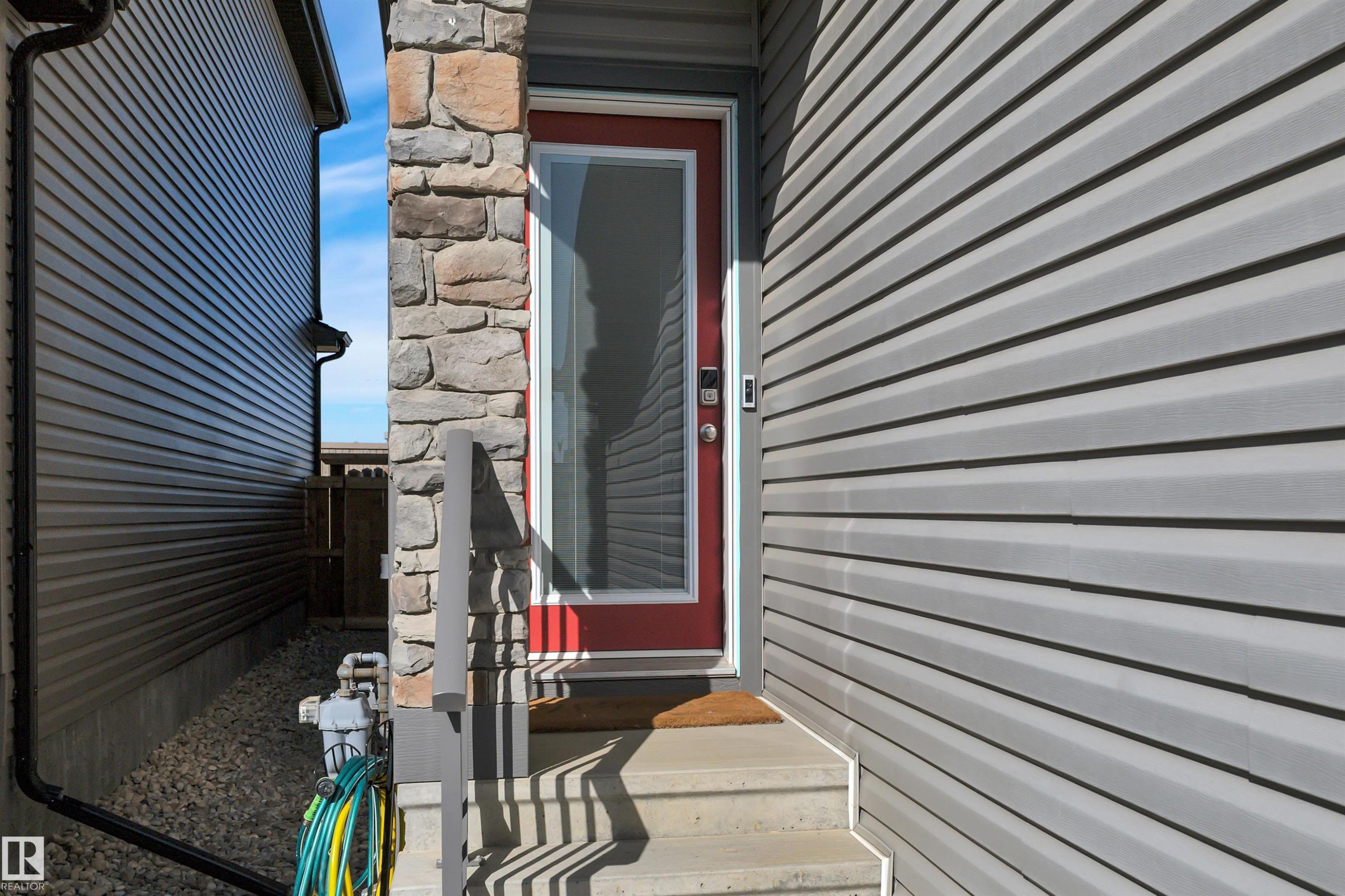 View of exterior entry with stone siding - 157 Larch Crescent, Leduc, AB - Outdoor With Exterior