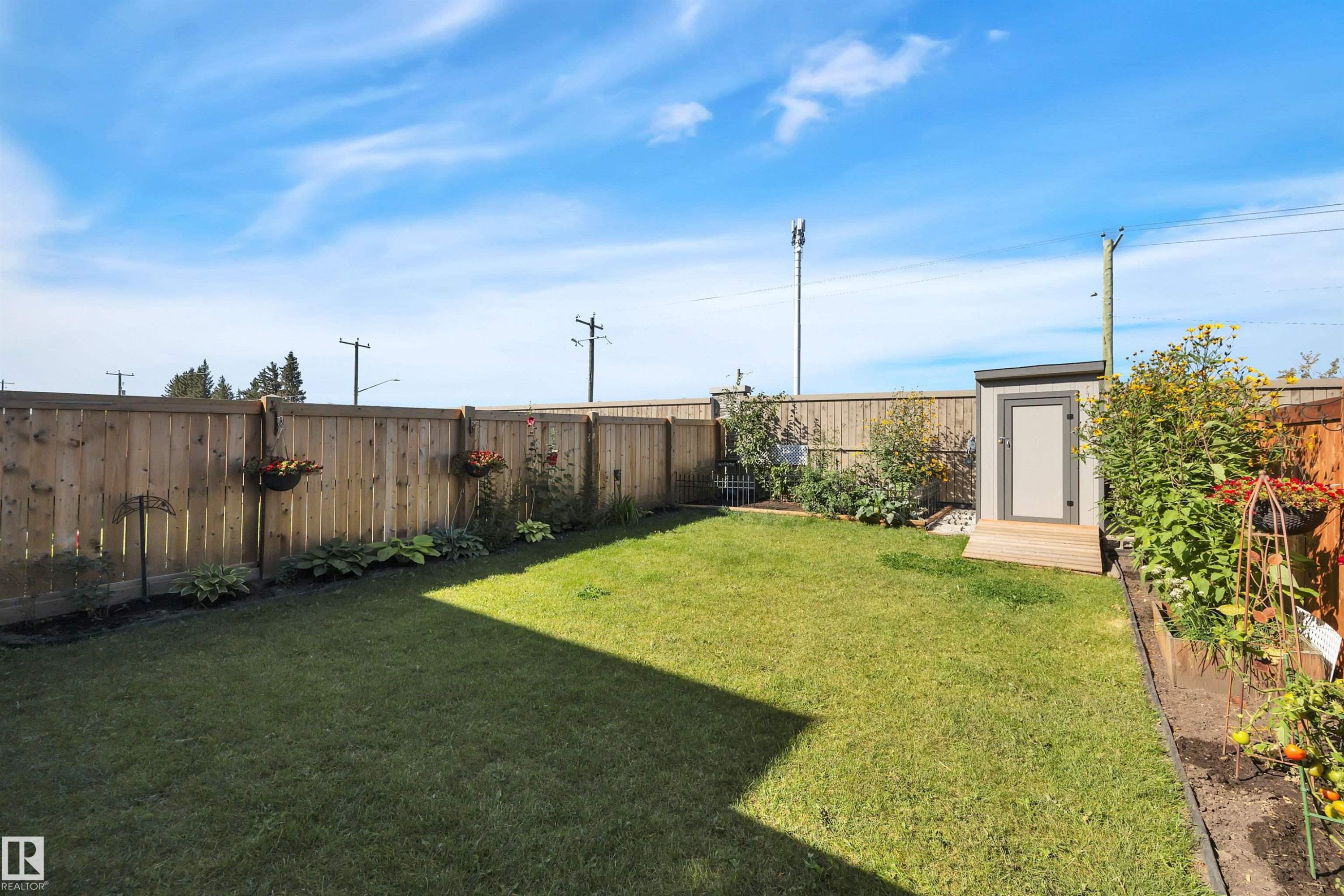Fenced backyard with an outdoor structure - 157 Larch Crescent, Leduc, AB - Outdoor