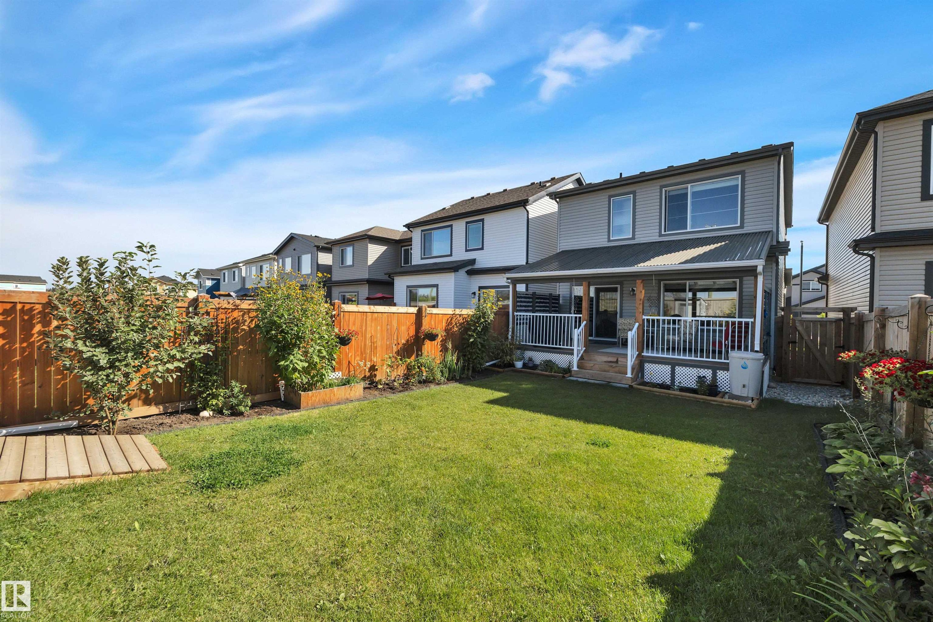 Back of house featuring a fenced backyard, a wooden deck, a residential view, and a gate - 157 Larch Crescent, Leduc, AB - Outdoor With Deck Patio Veranda