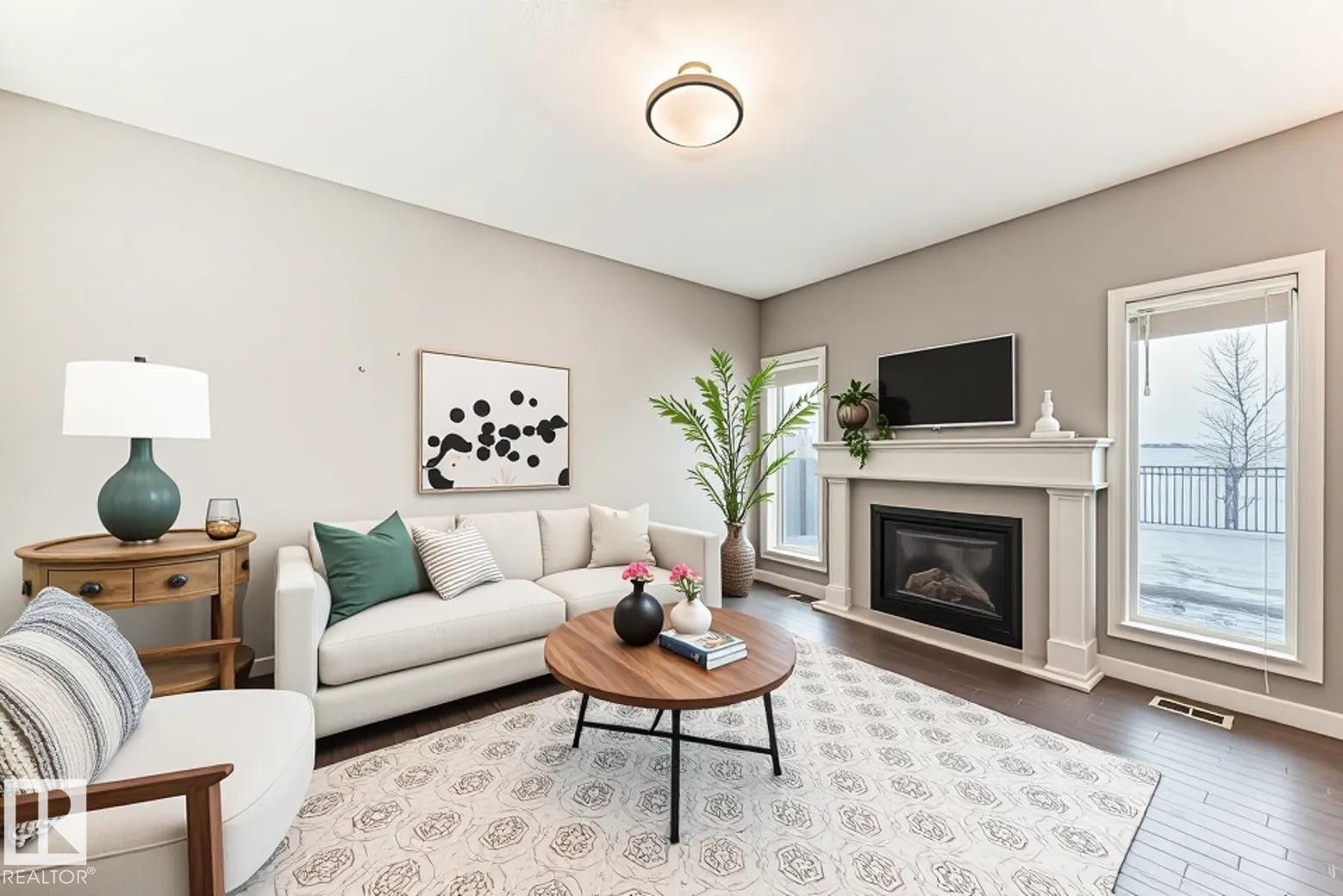 Living area with hardwood / wood-style floors and a glass covered fireplace - 1908 69 Street, Edmonton, AB - Indoor Photo Showing Living Room With Fireplace