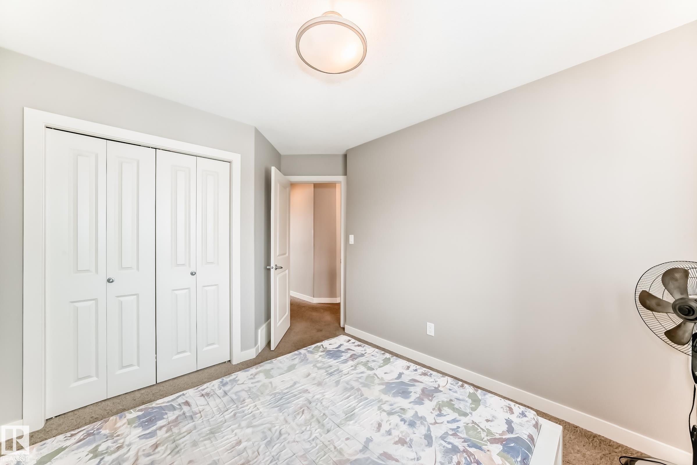 Carpeted bedroom featuring baseboards and a closet - 1908 69 Street, Edmonton, AB - Indoor