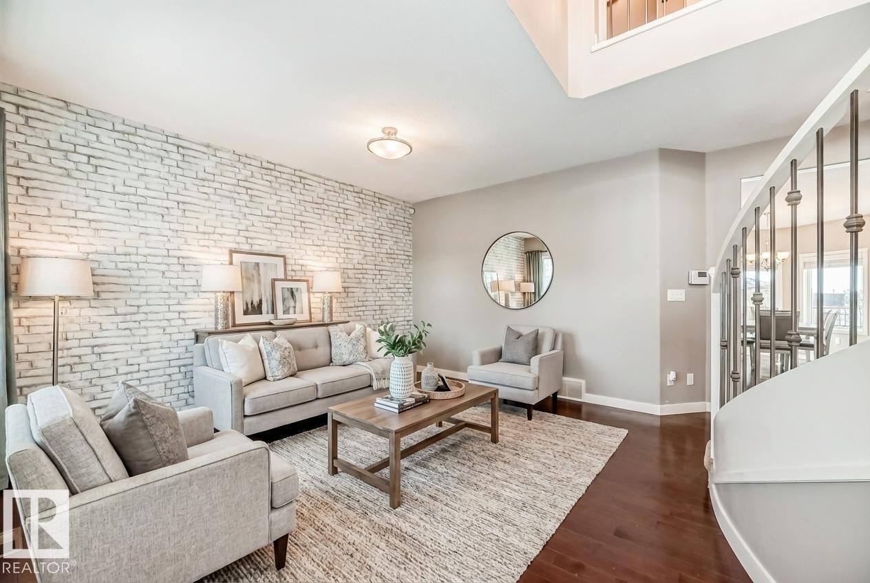 Living area with brick wall, dark wood-type flooring, and an accent wall - 1908 69 Street, Edmonton, AB - Indoor Photo Showing Living Room