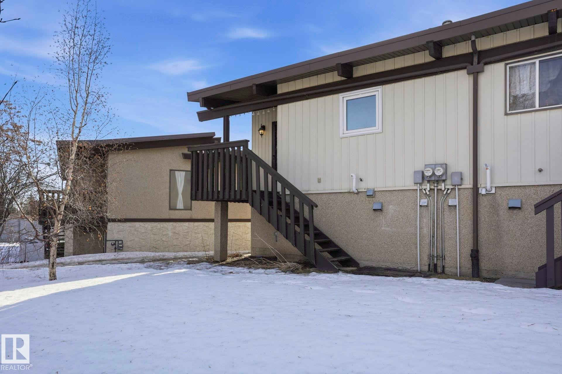 Snow covered back of property with stairway - Edmonton, AB - Outdoor With Exterior