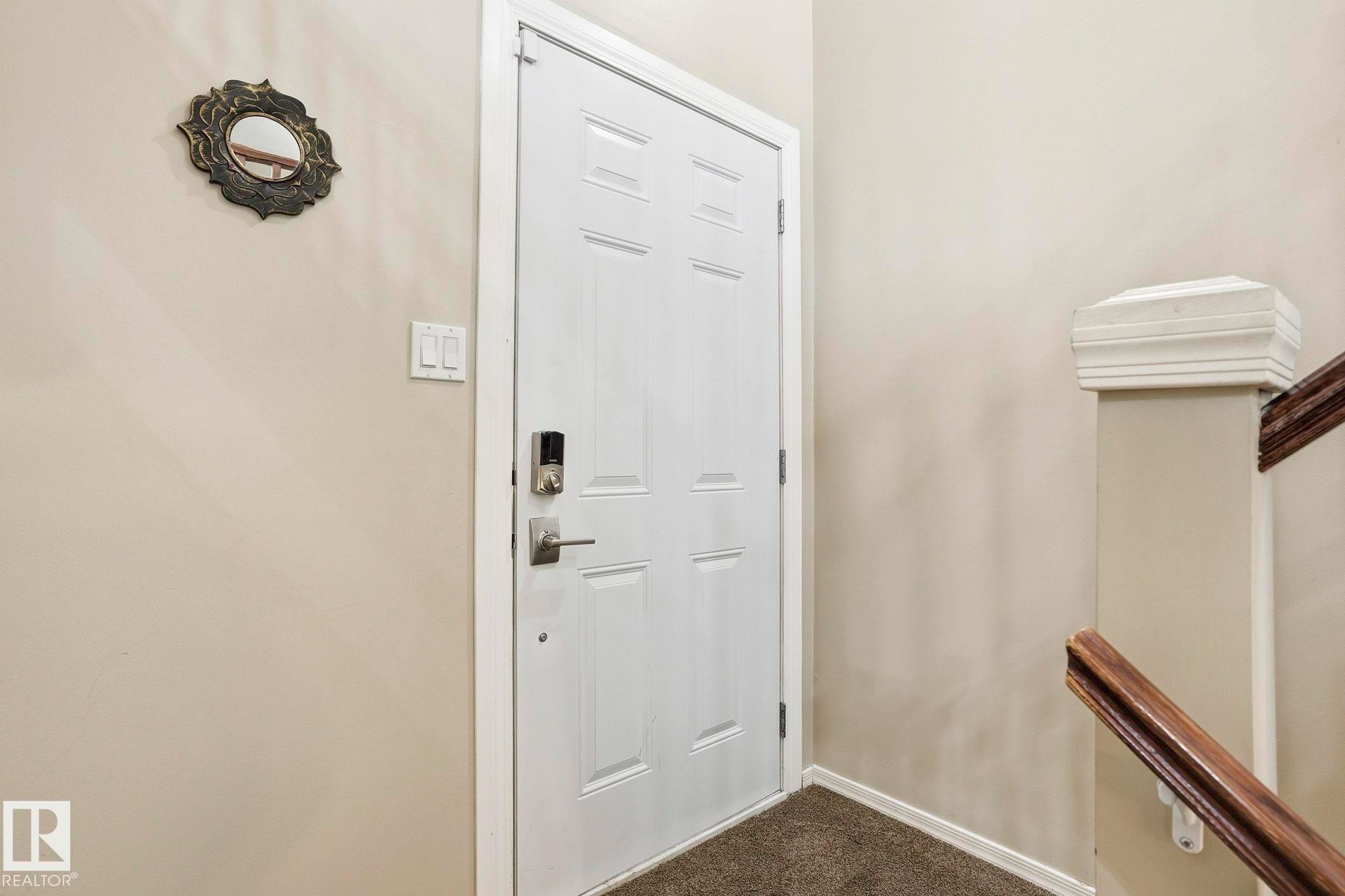 Doorway to outside featuring carpet and baseboards - Edmonton, AB - Indoor Photo Showing Other Room