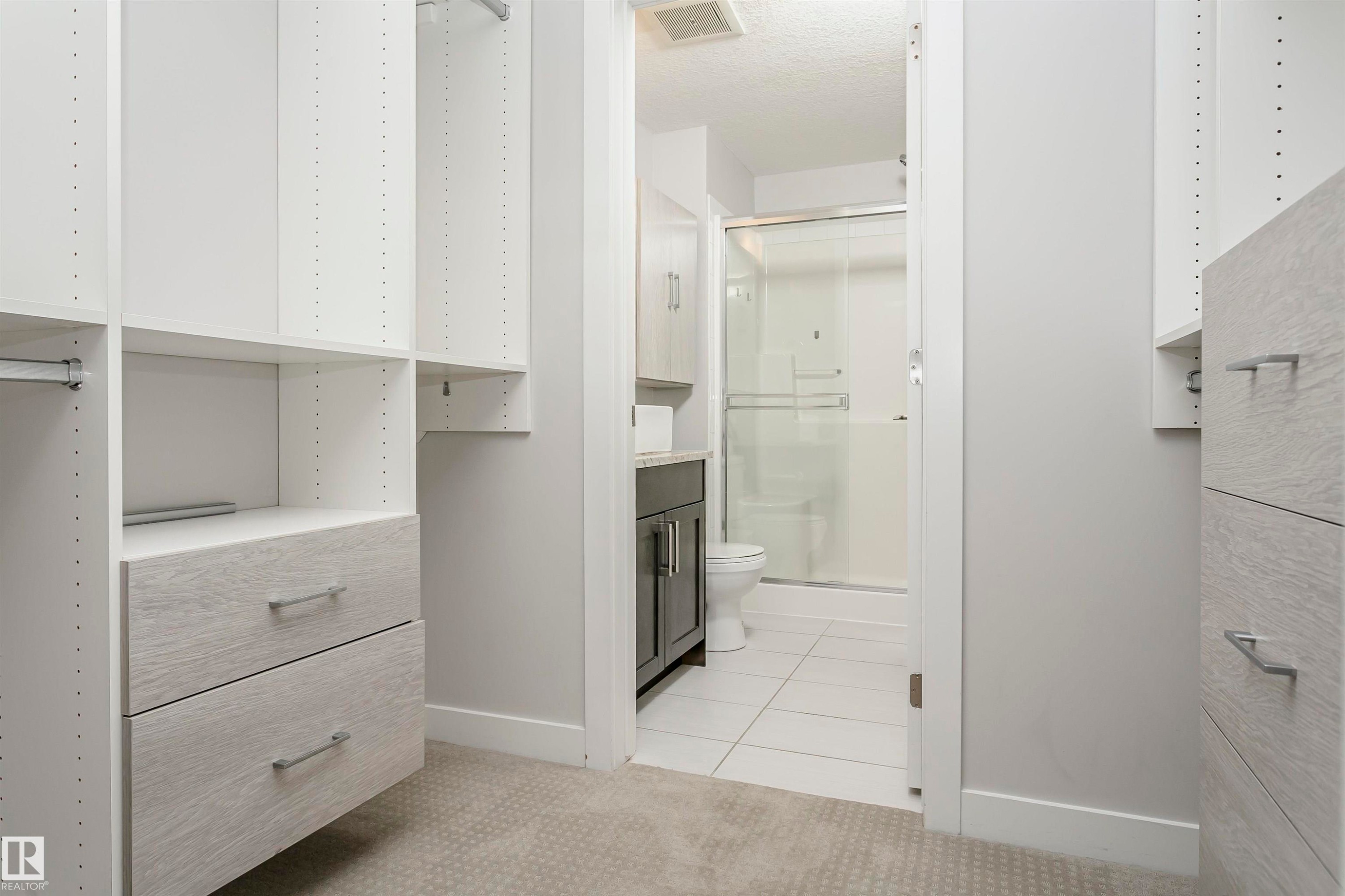 Walk in closet featuring light colored carpet - 332 5151 Windermere Boulevard, Edmonton, AB - Indoor
