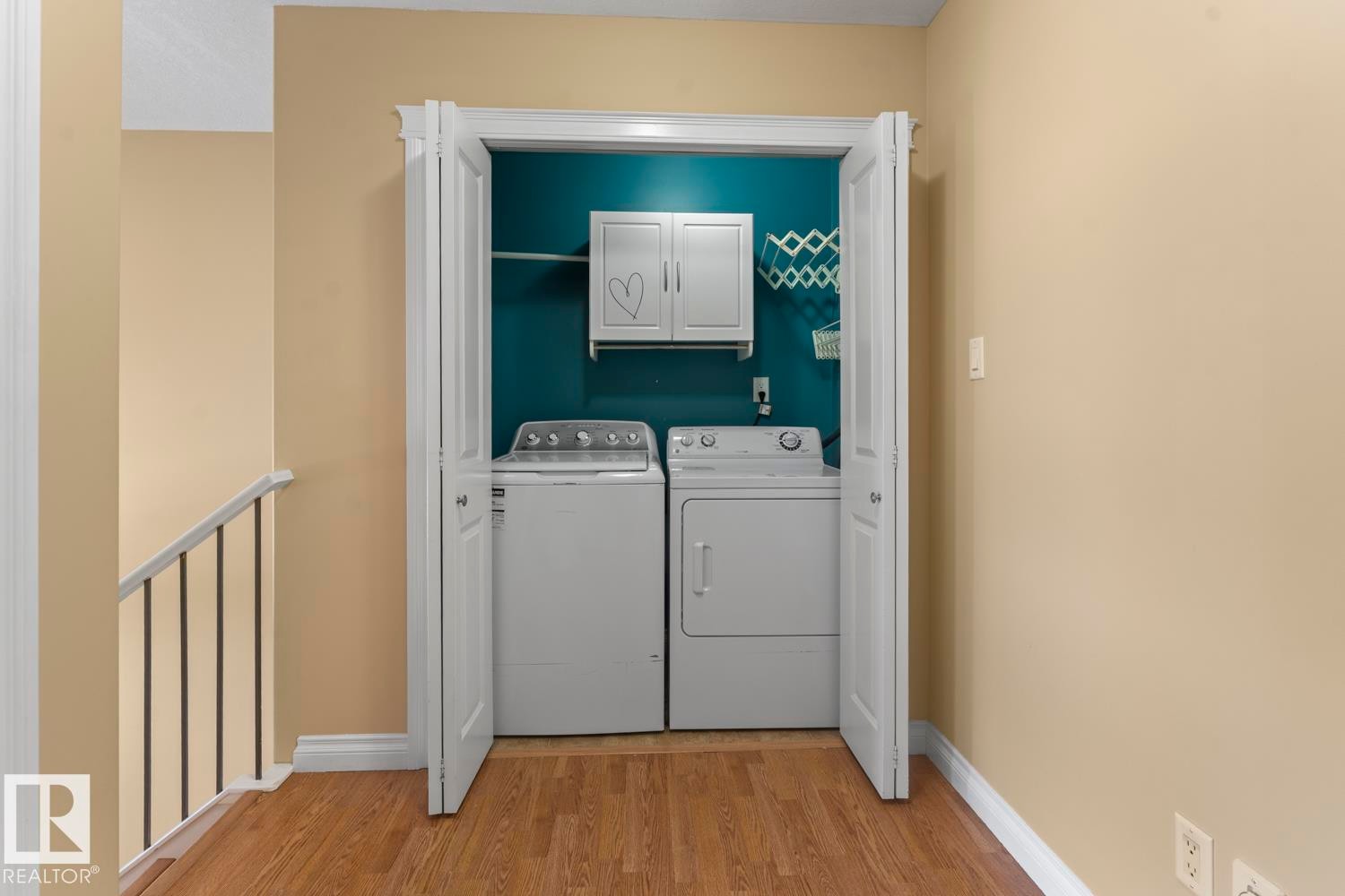 Laundry room with cabinet space, light wood-style floors, and separate washer and dryer - 7 1001 7 Avenue, Cold Lake, AB - Indoor Photo Showing Laundry Room