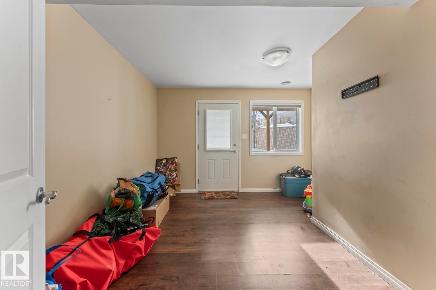 Doorway with wood finished floors and baseboards - 7 1001 7 Avenue, Cold Lake, AB - Indoor Photo Showing Other Room
