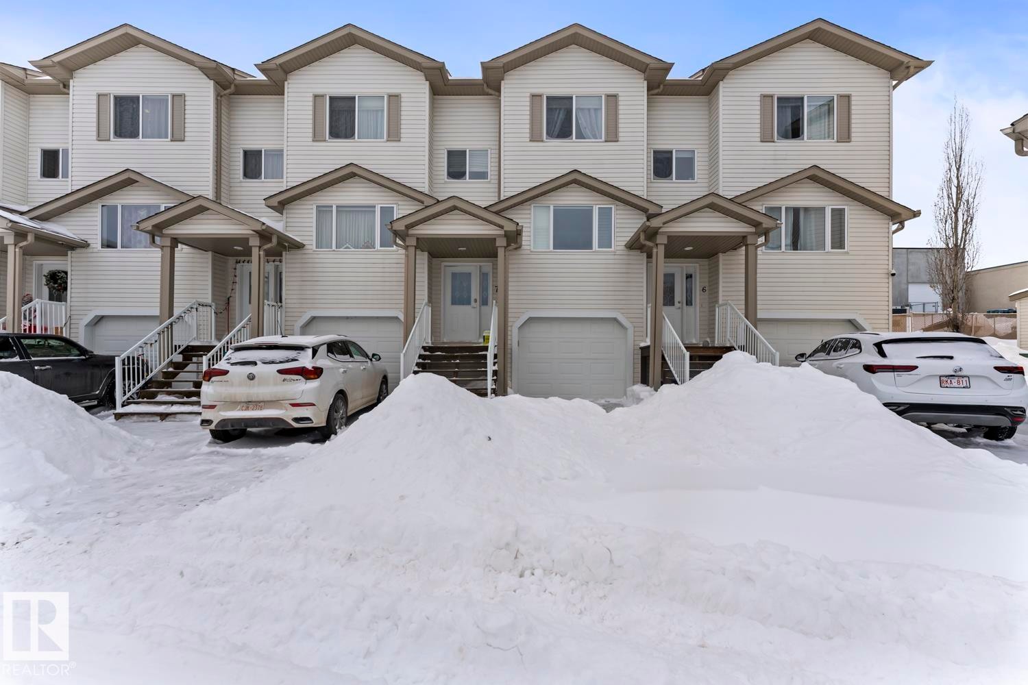 View of front of house with a garage and entry steps - 7 1001 7 Avenue, Cold Lake, AB - Outdoor With Facade
