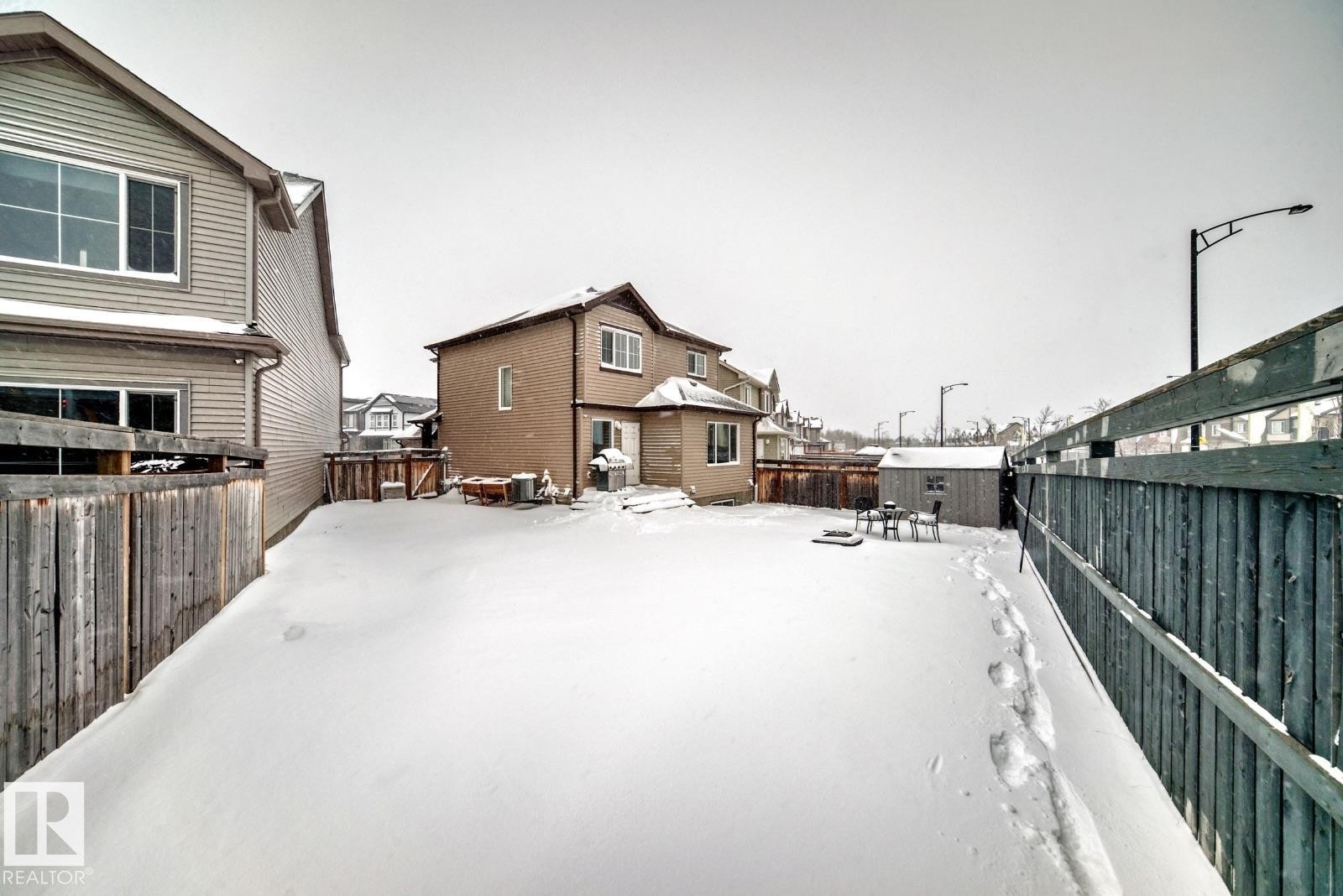 Snow covered house with a residential view and a fenced backyard - 2823 Duke Crescent, Edmonton, AB - Outdoor With Exterior