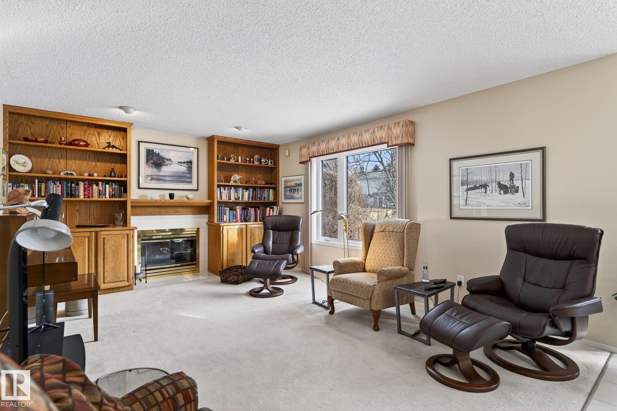 Sitting room featuring a fireplace, a textured ceiling, and light colored carpet - 313 Hedley Way, Edmonton, AB - Indoor With Fireplace
