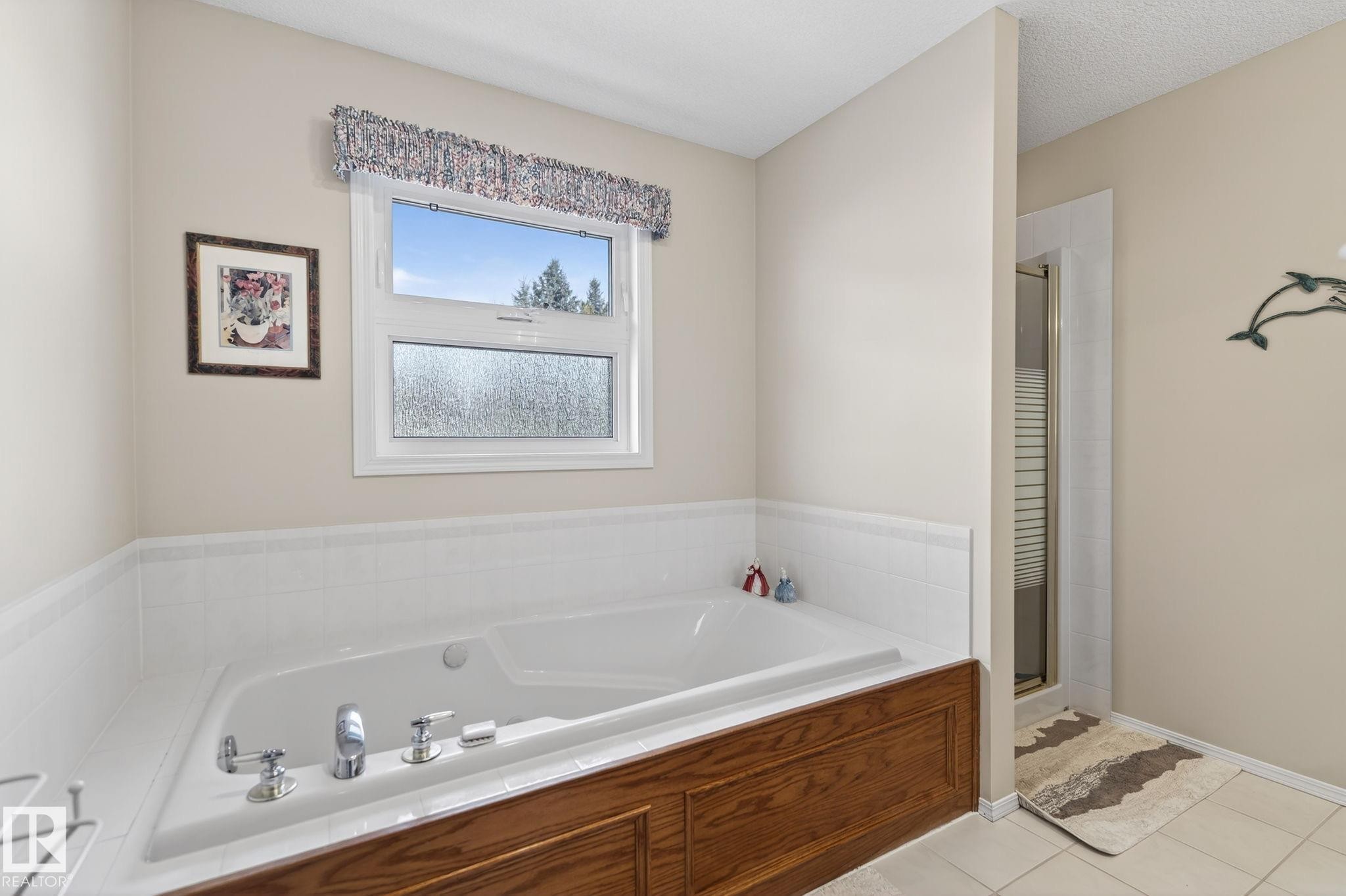 Bathroom featuring a bath, a shower stall, and light tile patterned floors - 313 Hedley Way, Edmonton, AB - Indoor Photo Showing Bathroom