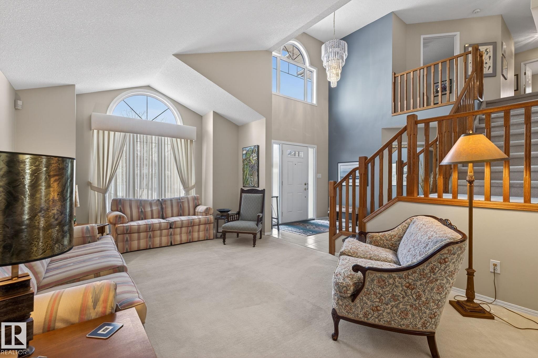 Living area with carpet, hanging lights, and lofted ceiling - 313 Hedley Way, Edmonton, AB - Indoor