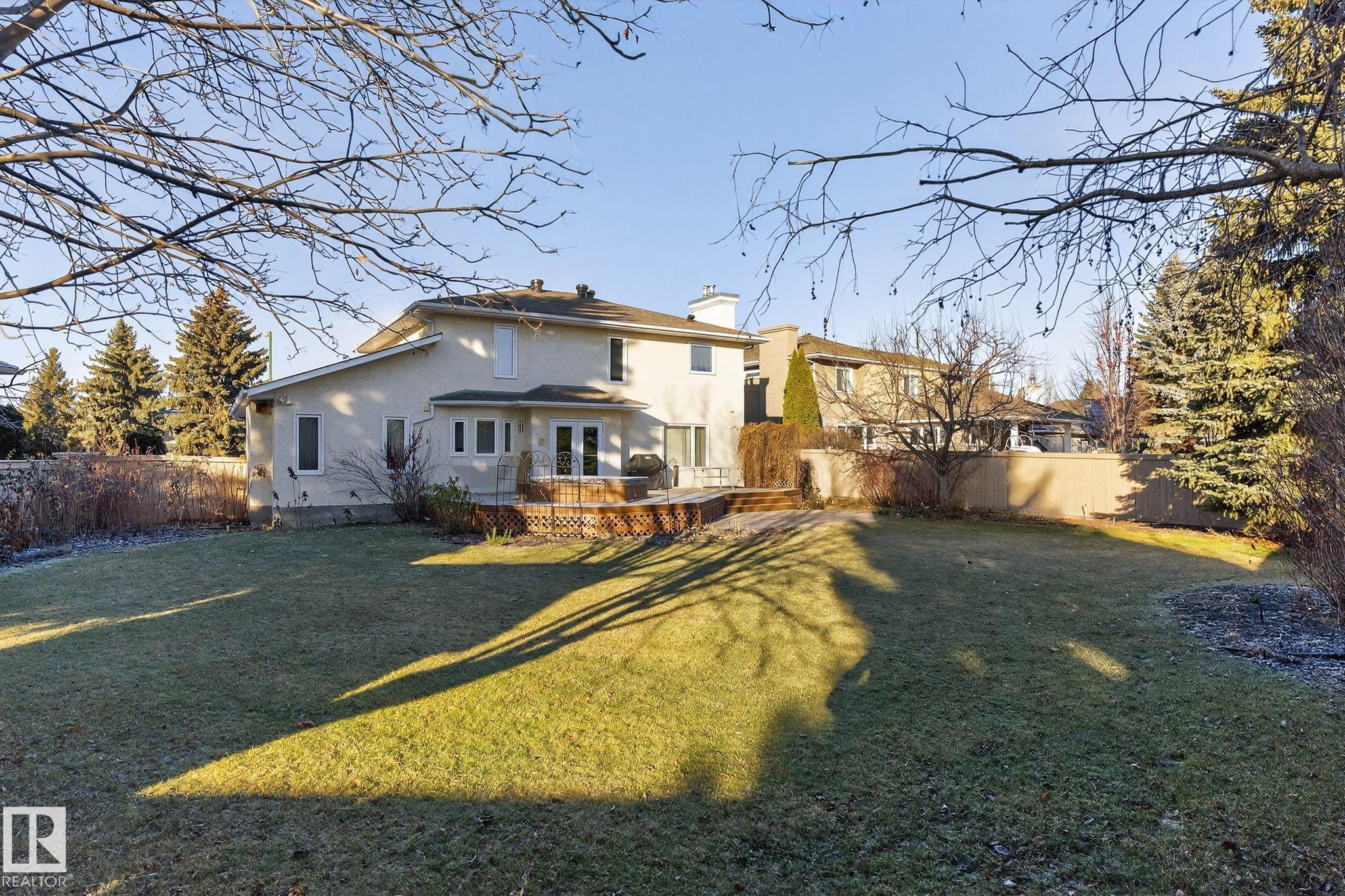 Back of property featuring stucco siding, a fenced backyard, a chimney, and a deck - 313 Hedley Way, Edmonton, AB - Outdoor