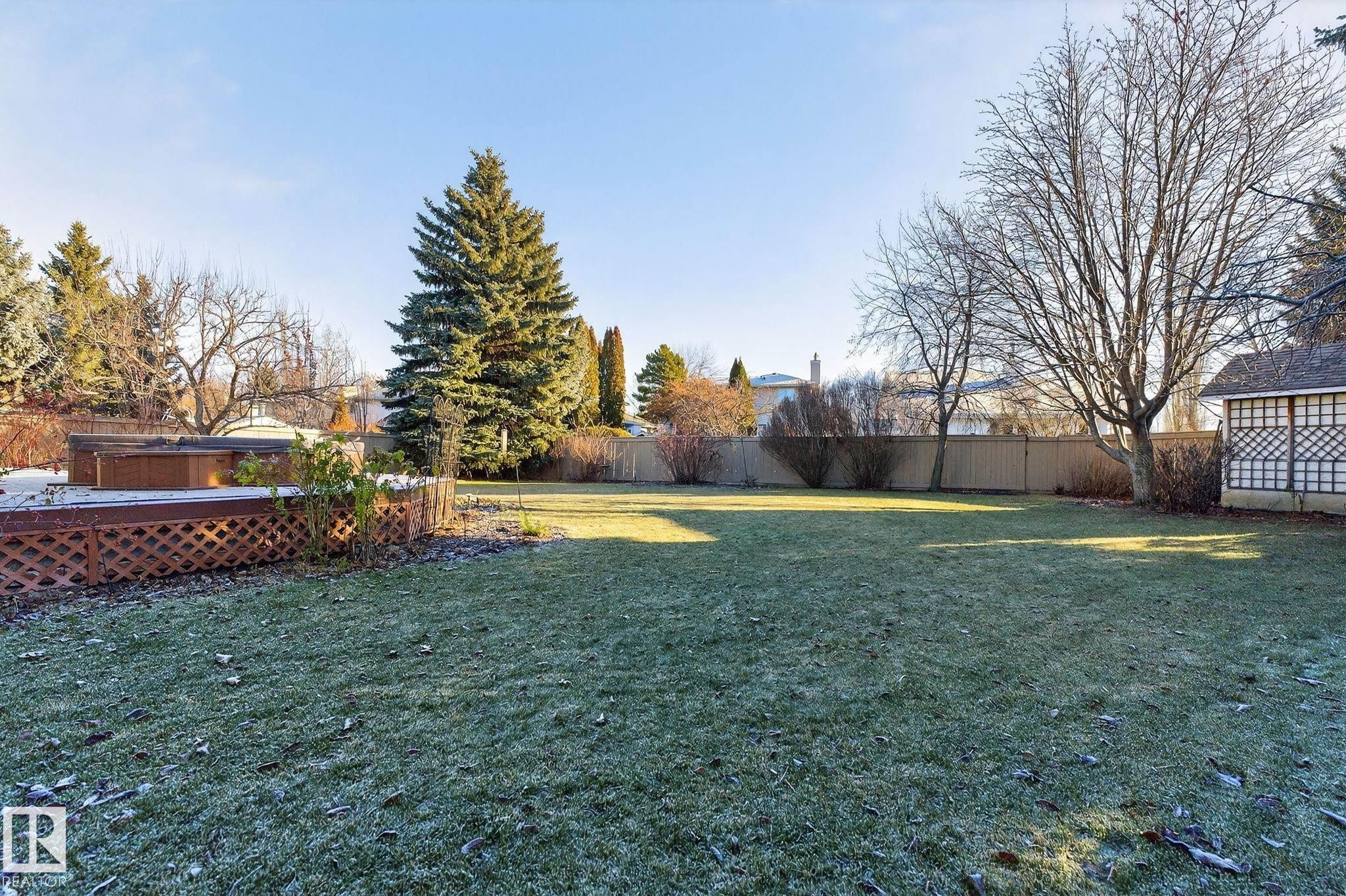 Fenced backyard featuring a hot tub and a wooden deck - 313 Hedley Way, Edmonton, AB - Outdoor