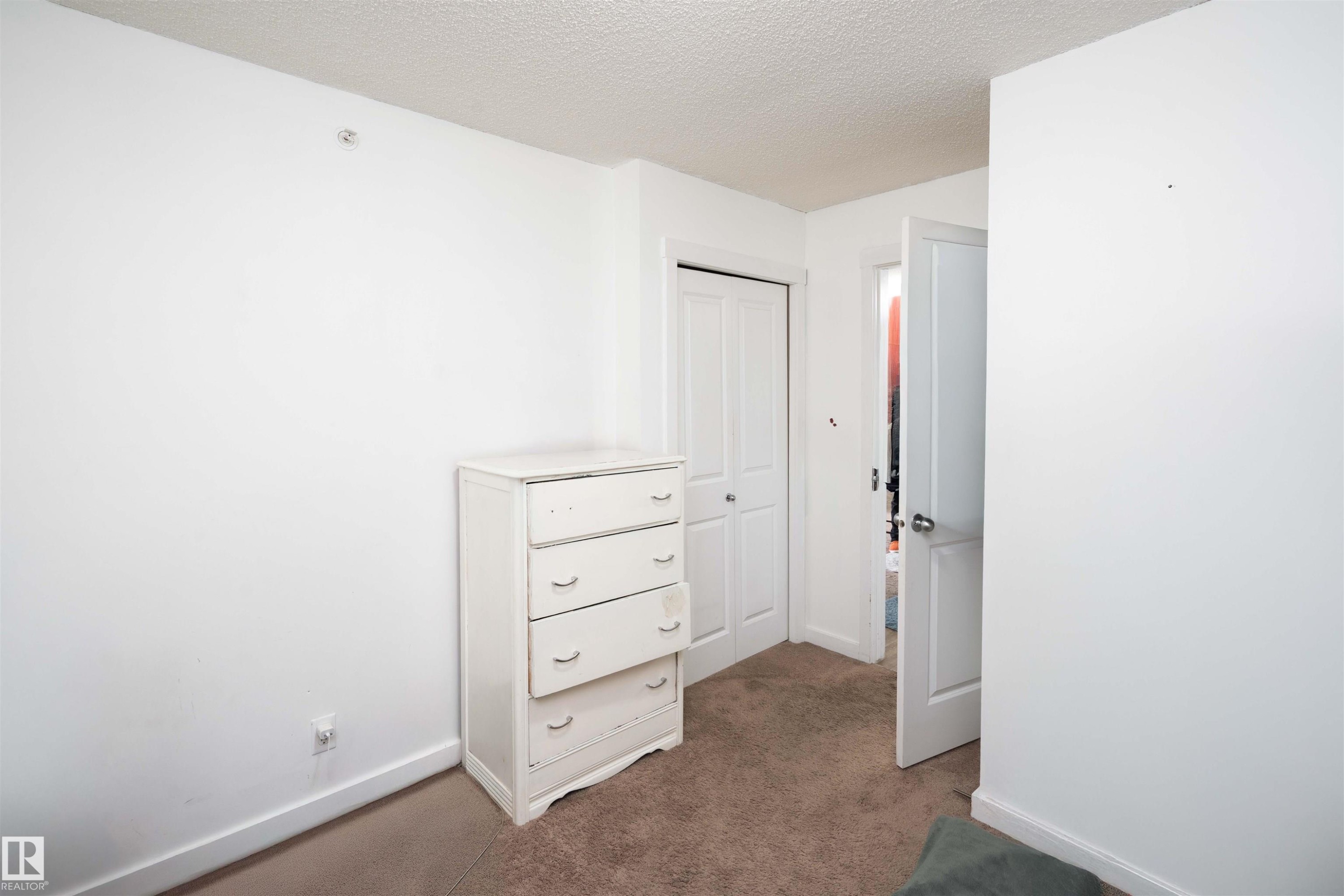 Unfurnished bedroom with a textured ceiling, carpet, and a closet - 415 111 Watt Common, Edmonton, AB - Indoor Photo Showing Other Room