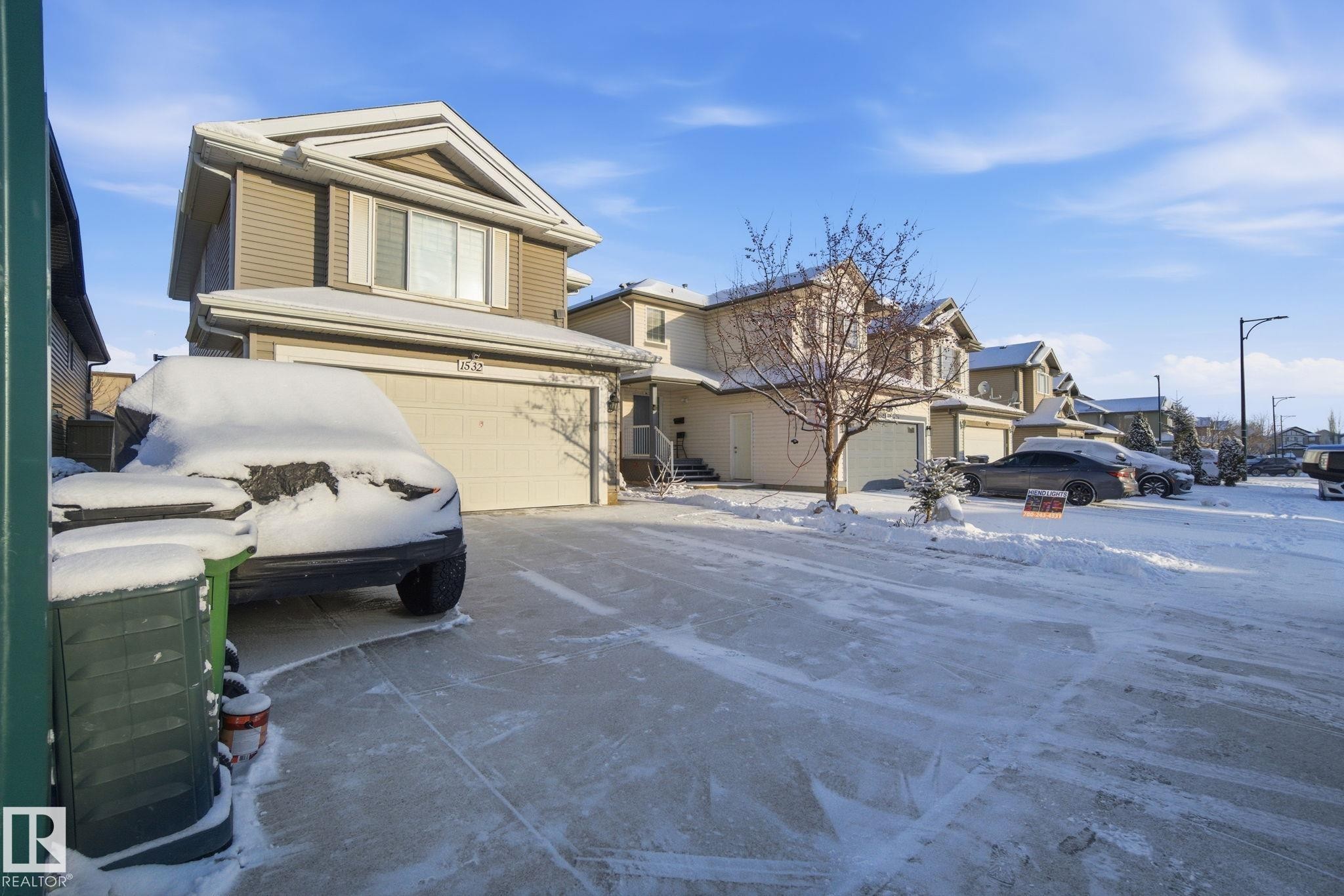 View of front of property featuring an attached garage, a residential view, and concrete driveway - 1532 37C Avenue, Edmonton, AB - Outdoor