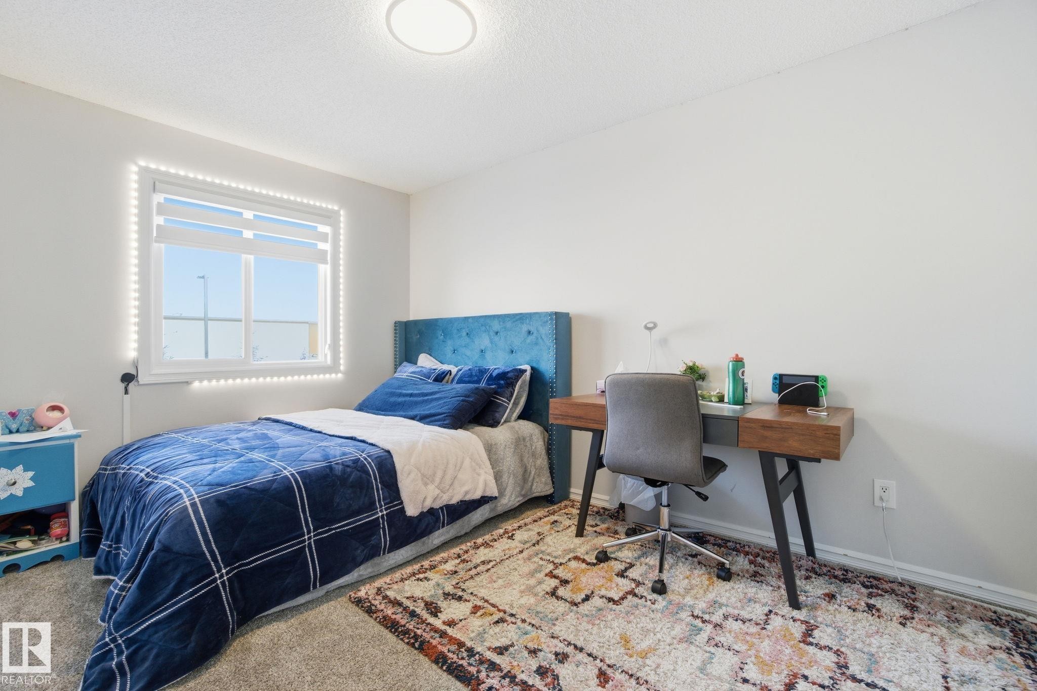 Carpeted bedroom featuring an office area and baseboards - 1532 37C Avenue, Edmonton, AB - Indoor Photo Showing Bedroom