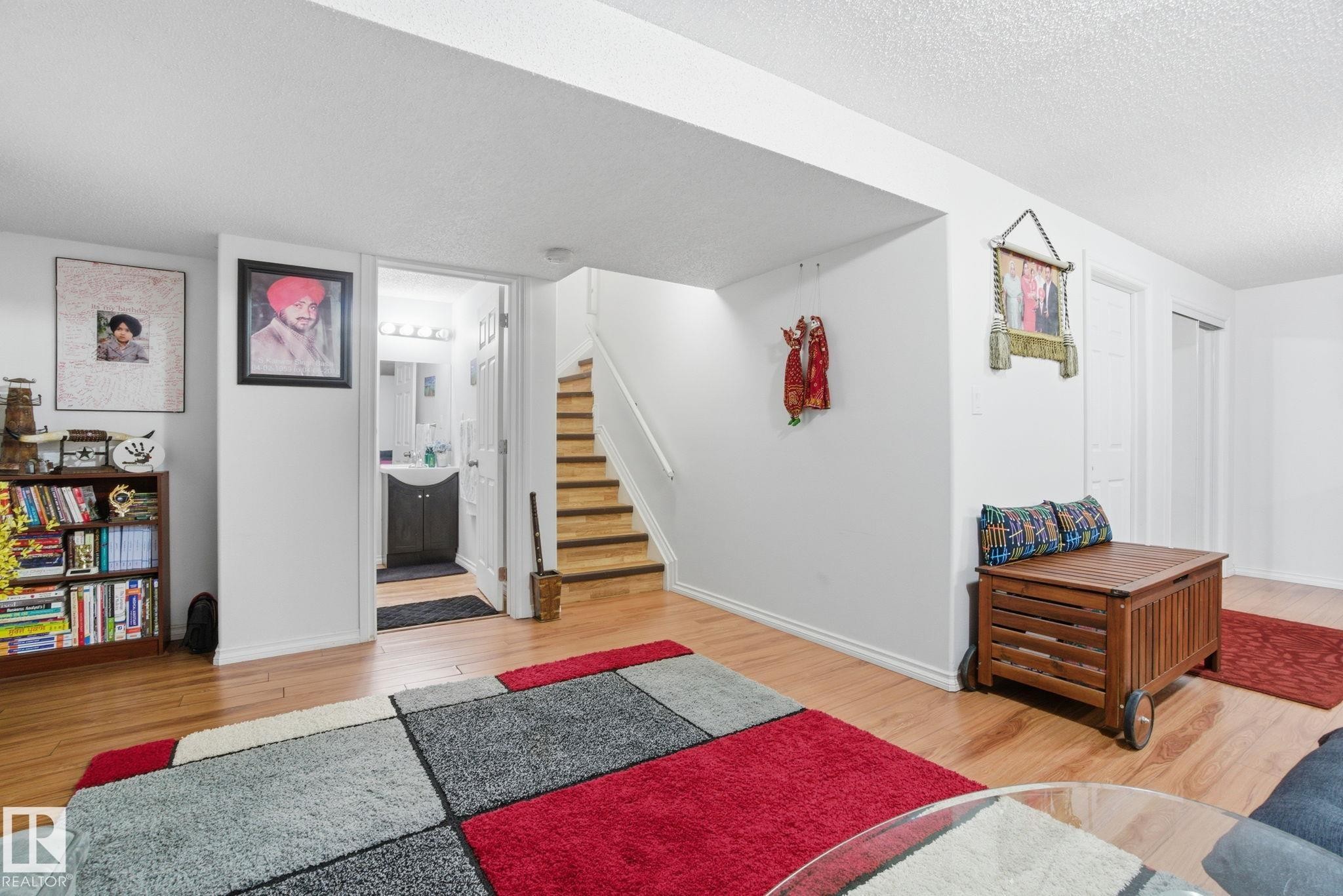 Living area with light wood-type flooring, a textured ceiling, and stairway - 1532 37C Avenue, Edmonton, AB - Indoor Photo Showing Living Room