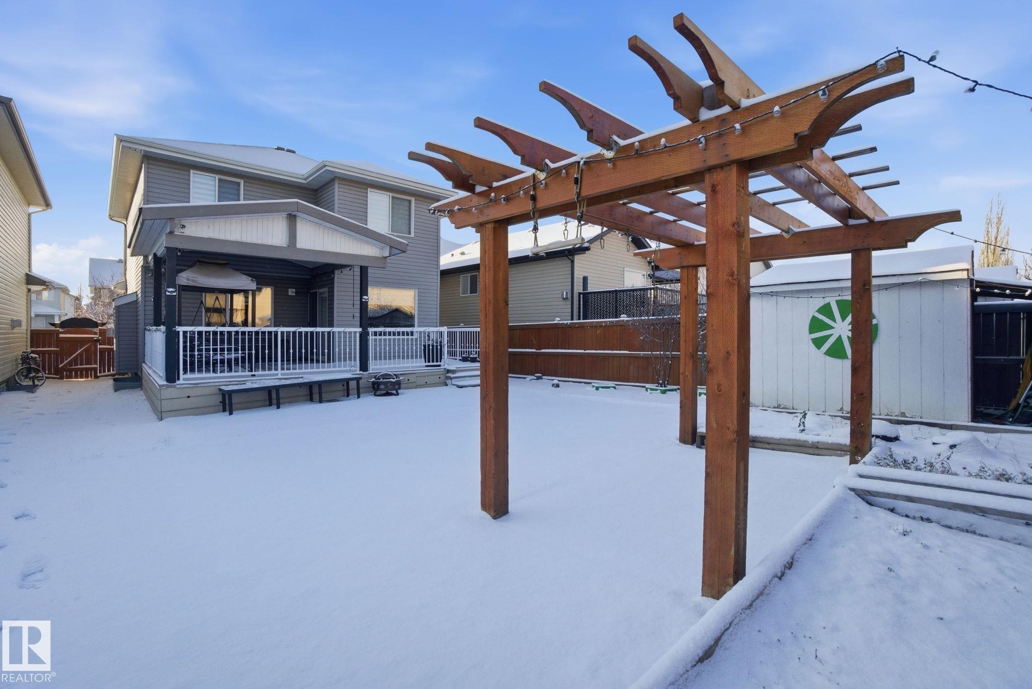 Snow covered patio featuring a deck, a shed, and a gate - 1532 37C Avenue, Edmonton, AB - Outdoor