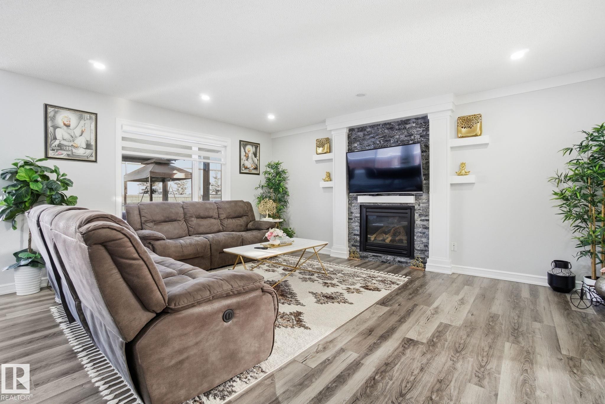 Living room featuring light wood finished floors, a glass covered fireplace, and recessed lighting - 1532 37C Avenue, Edmonton, AB - Indoor Photo Showing Living Room With Fireplace