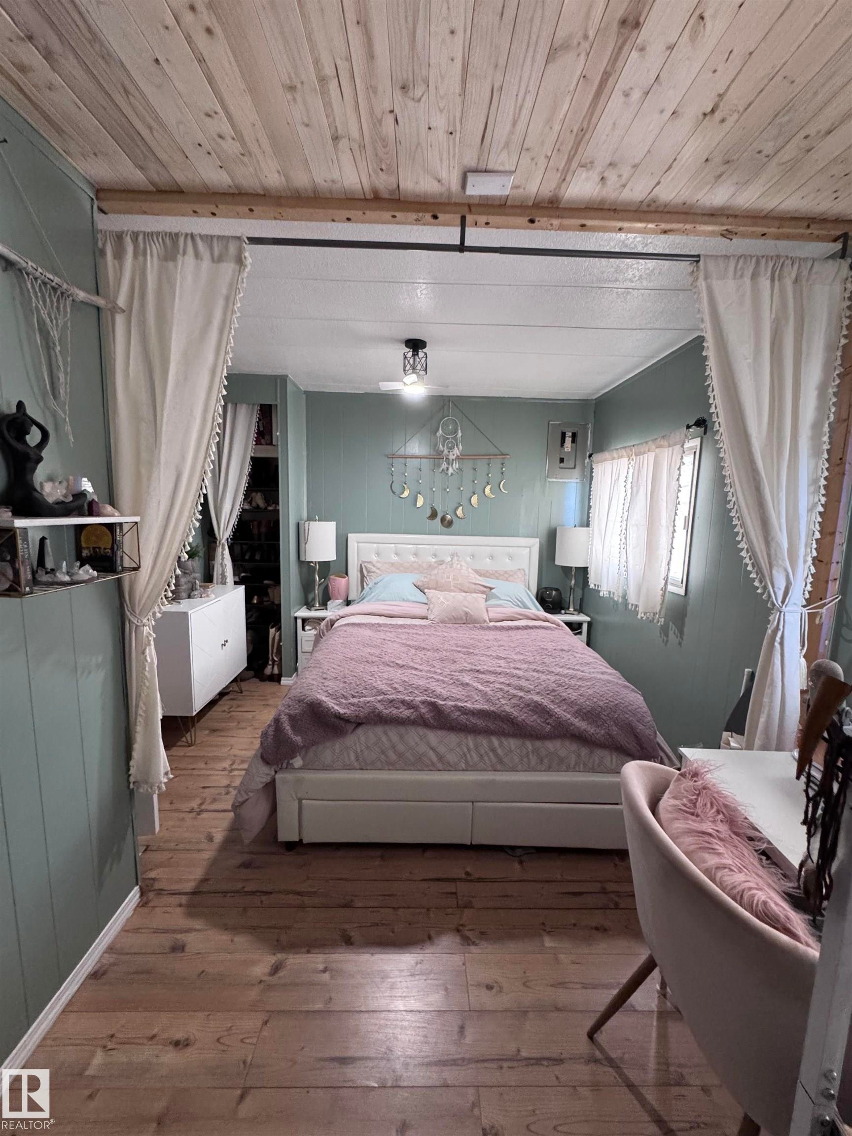 Bedroom featuring hardwood / wood-style floors and wooden ceiling - #44 9501 104 Ave, Westlock, AB - Indoor Photo Showing Bedroom