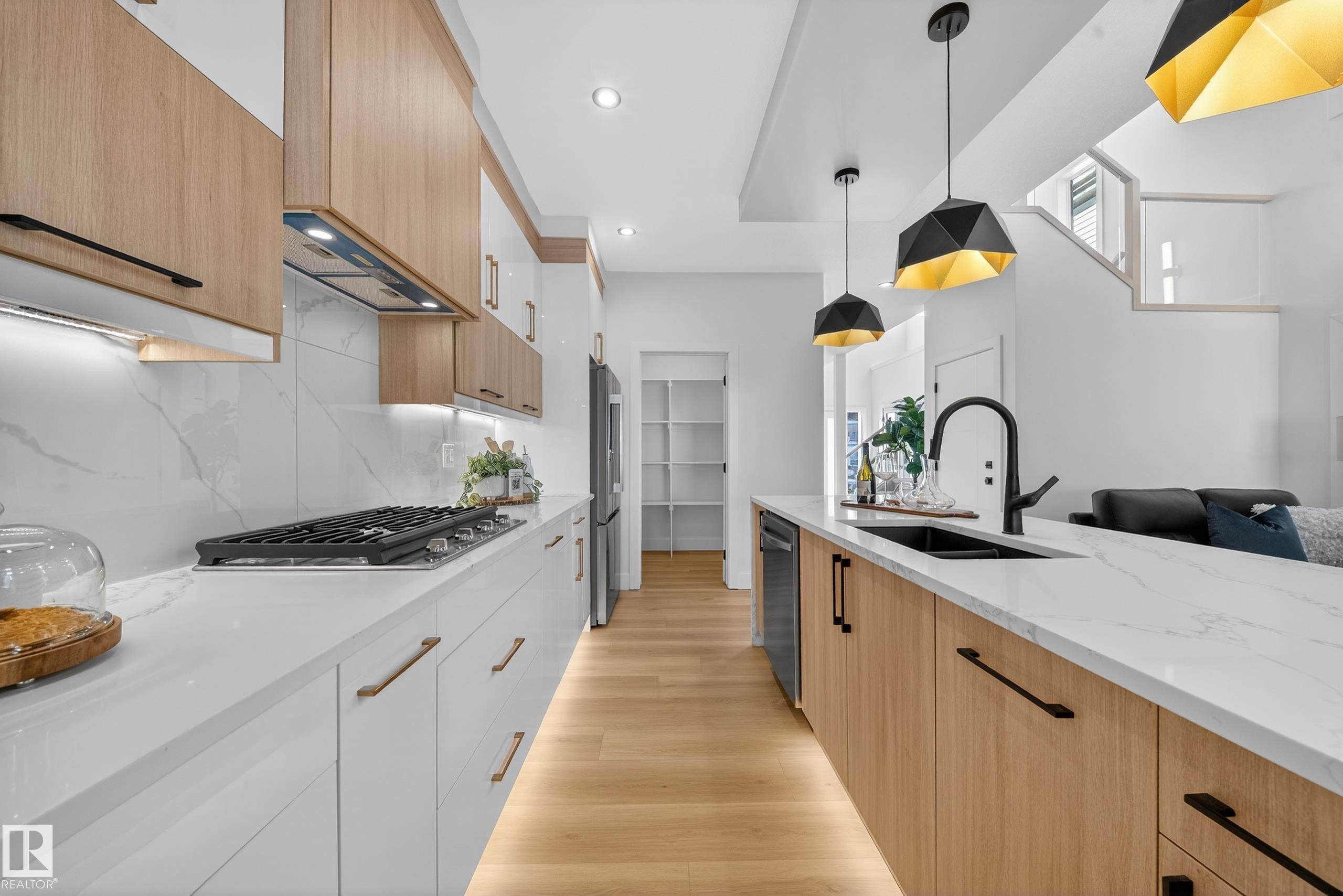 Two tone kitchen with dual tone cabinets, modern cabinets, light stone counters, pendant lighting, and light wood-style flooring - 9907 68 Street, Edmonton, AB - Indoor Photo Showing Kitchen With Double Sink With Upgraded Kitchen