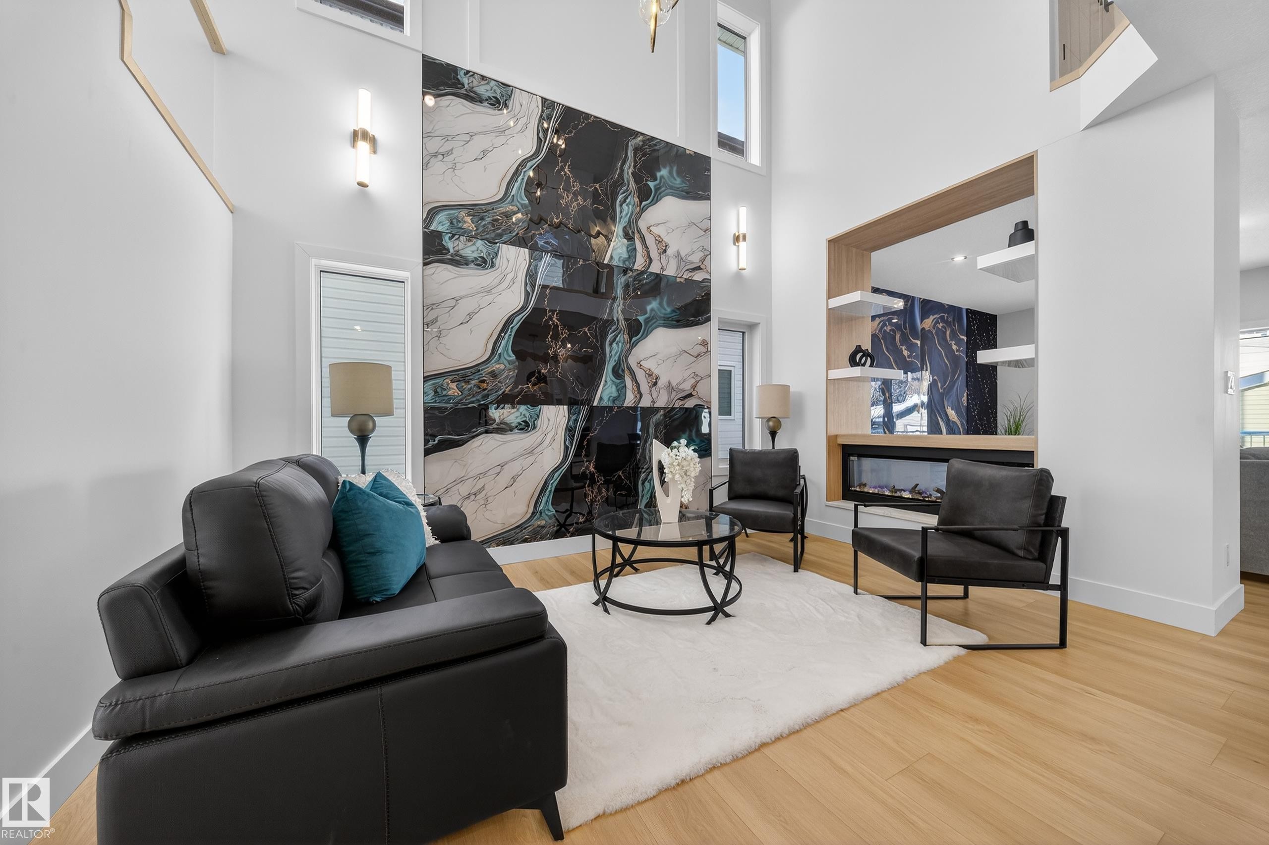 Living room featuring a premium fireplace, a high ceiling, wood finished floors, and healthy amount of natural light - 9907 68 Street, Edmonton, AB - Indoor With Fireplace