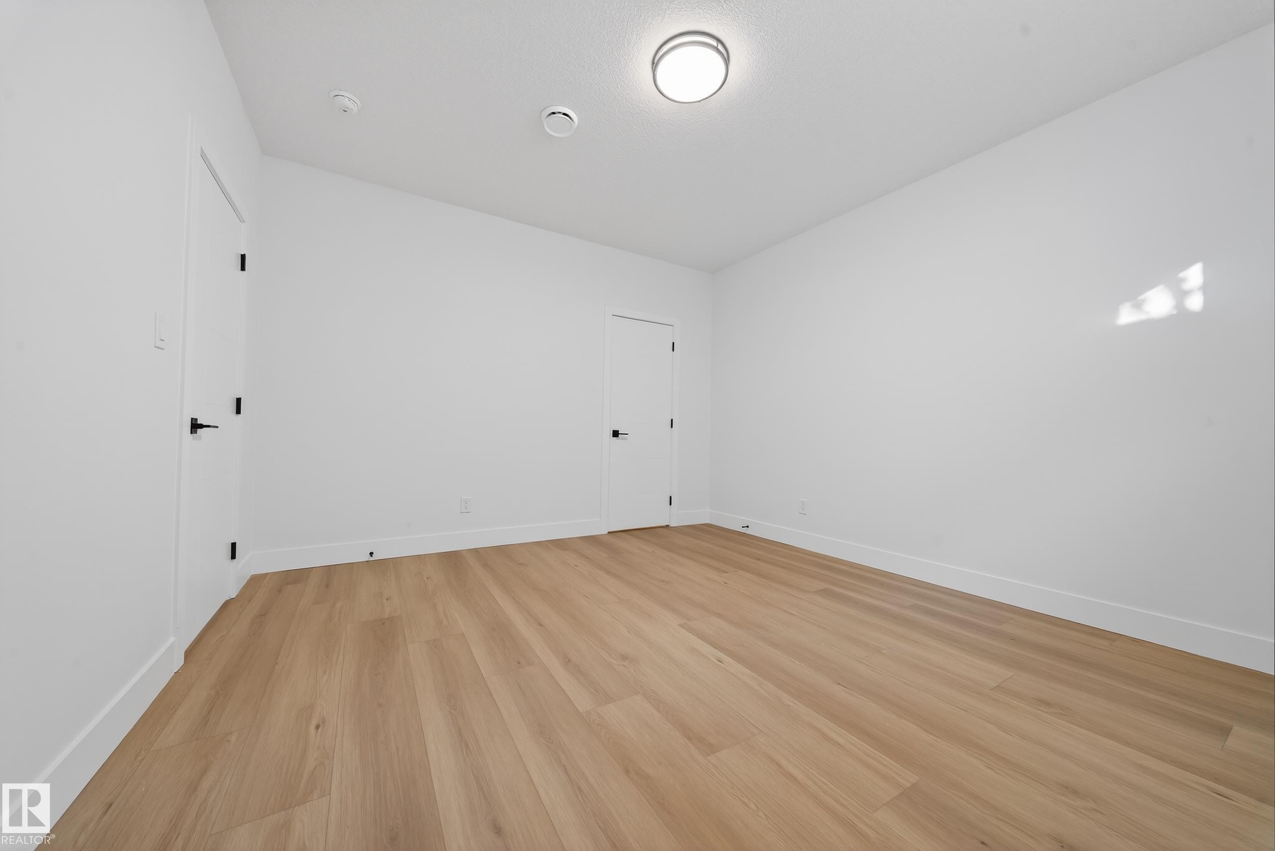 Empty room featuring light wood-style flooring and baseboards - 9907 68 Street, Edmonton, AB - Indoor Photo Showing Other Room