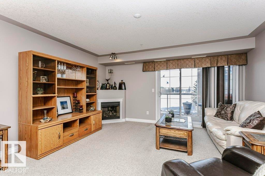 325 7801 Golf Course Road, Stony Plain, AB - Indoor Photo Showing Living Room With Fireplace