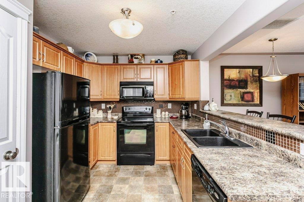 325 7801 Golf Course Road, Stony Plain, AB - Indoor Photo Showing Kitchen With Double Sink