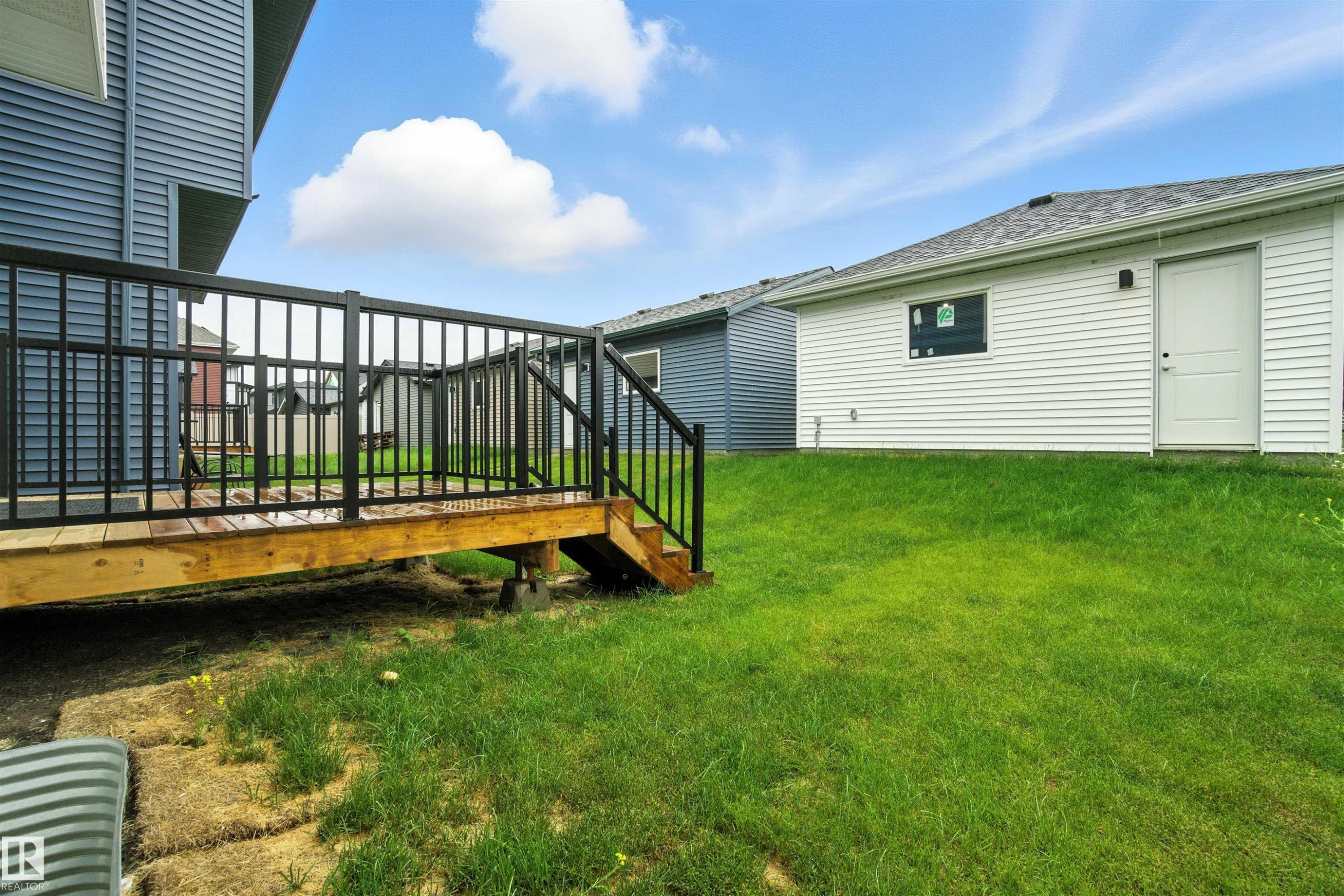 View of grassy yard with a deck and stairway - 20727 25 Ave, Edmonton, AB - Outdoor
