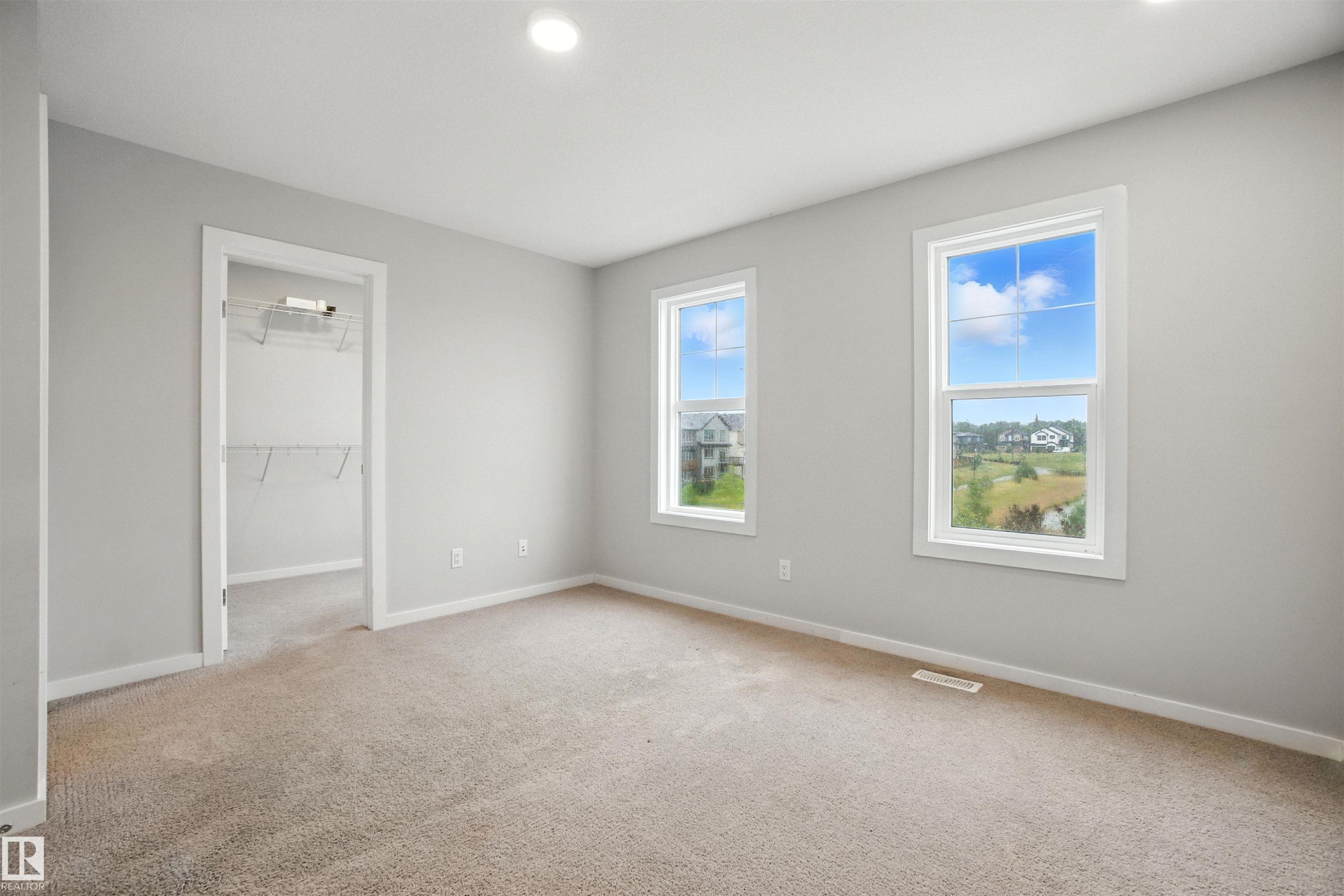 Unfurnished bedroom with a walk in closet, light colored carpet, and recessed lighting - 20727 25 Ave, Edmonton, AB - Indoor Photo Showing Other Room