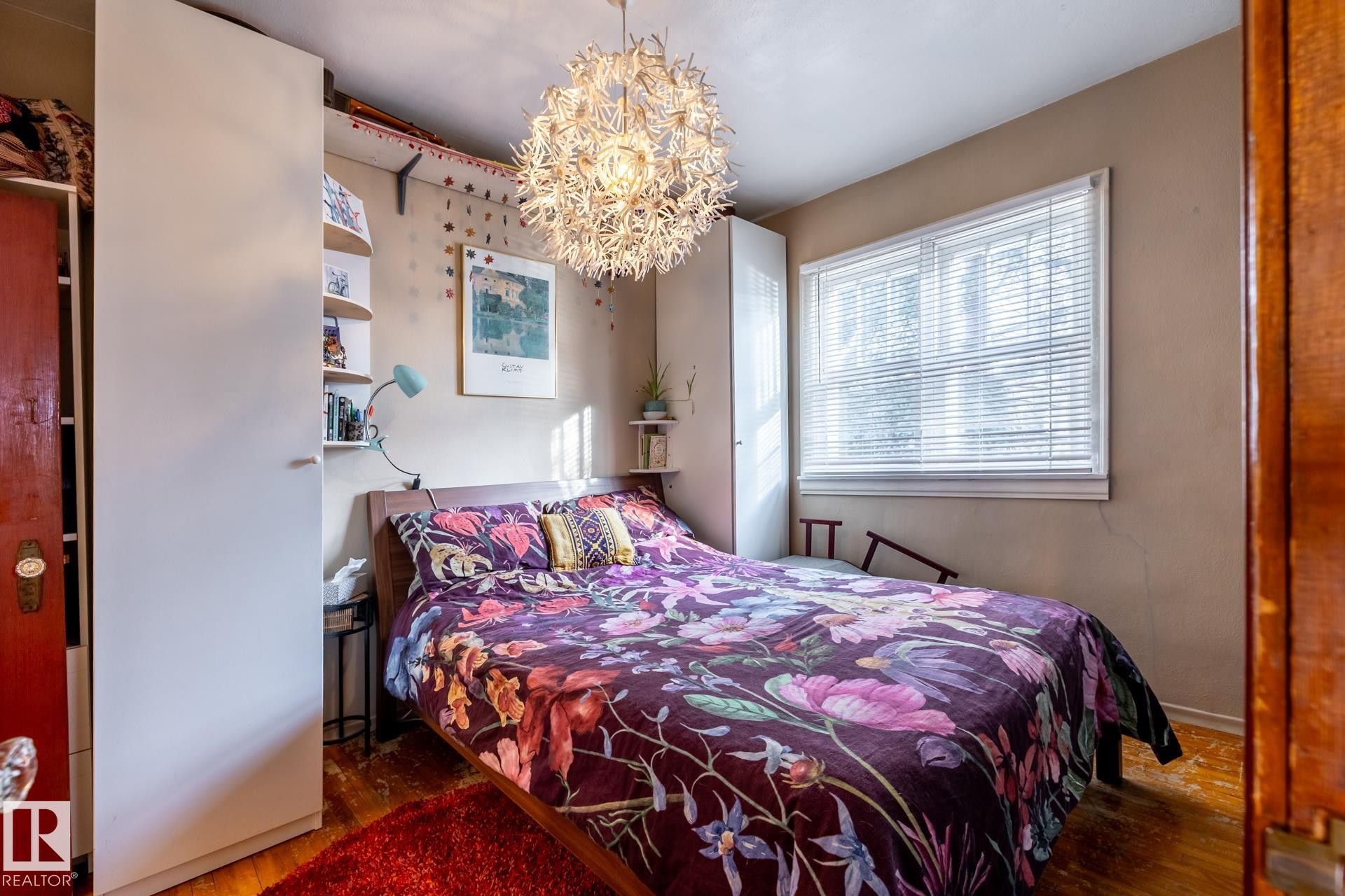 Bedroom with wood finished floors and hanging lights - 11240 84 Street, Edmonton, AB - Indoor Photo Showing Bedroom