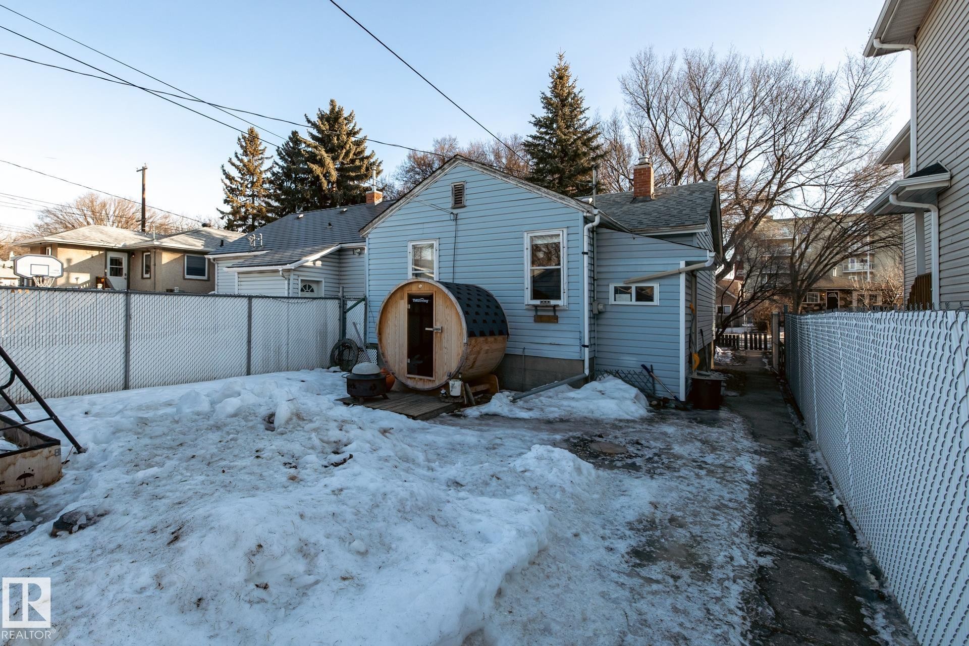 Snow covered rear of property with a fenced backyard, a chimney, and heating fuel - 11240 84 Street, Edmonton, AB - Outdoor