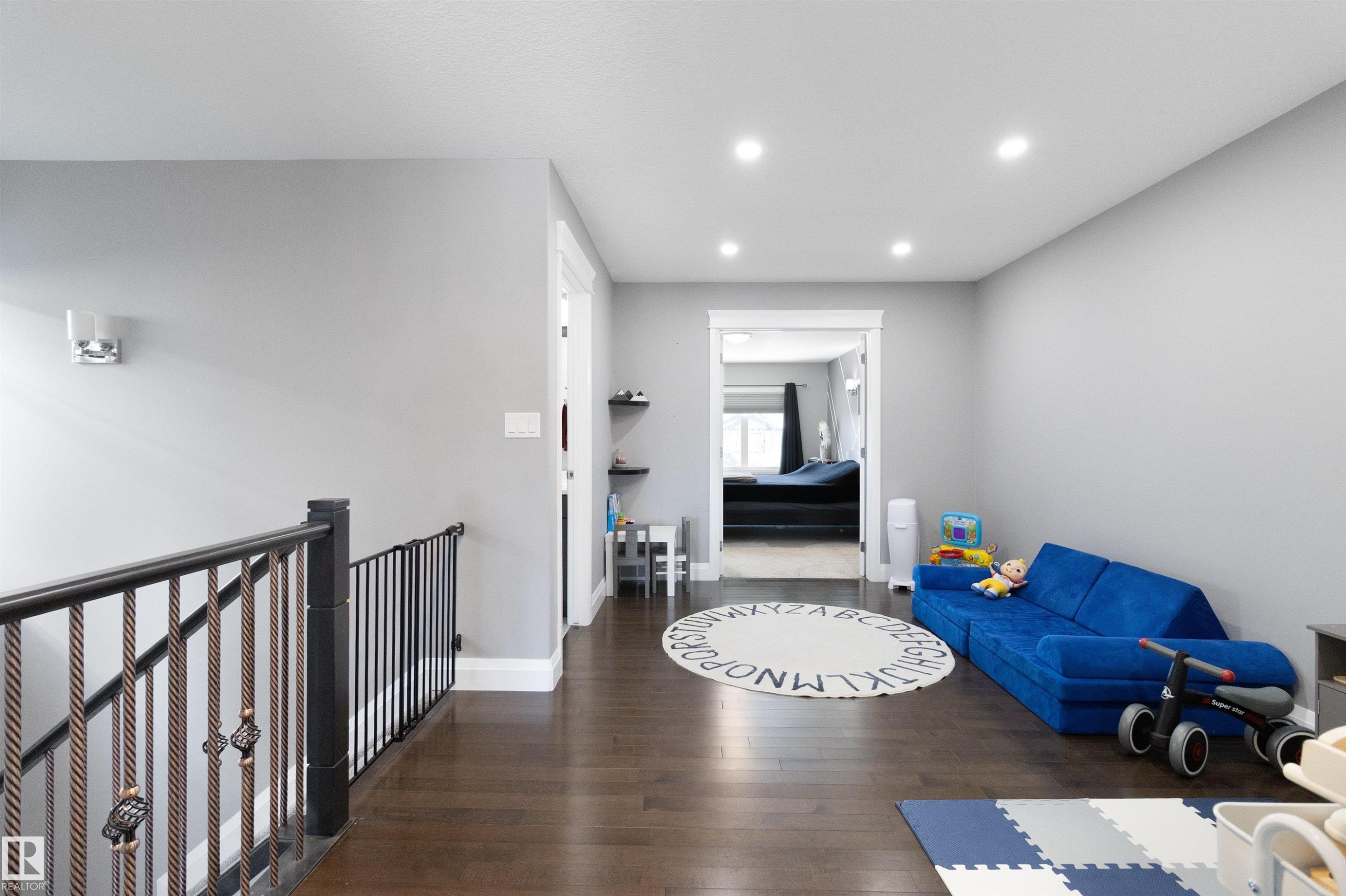 Living area with dark wood-style floors and recessed lighting - 56 Durrand Bend, Fort Saskatchewan, AB - Indoor Photo Showing Other Room