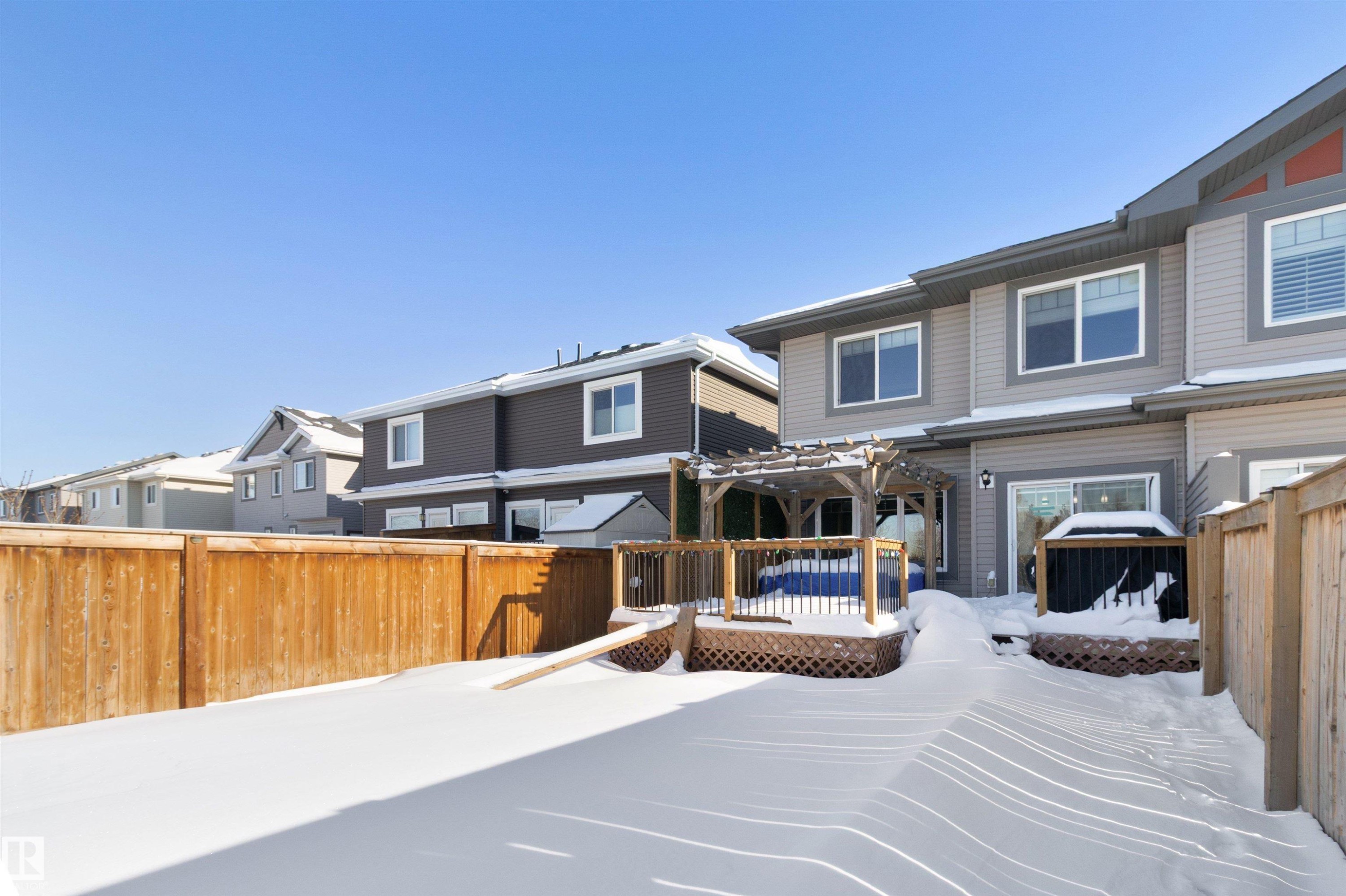 Rear view of house with a residential view, a deck, a fenced backyard, and a pergola - 56 Durrand Bend, Fort Saskatchewan, AB - Outdoor With Deck Patio Veranda