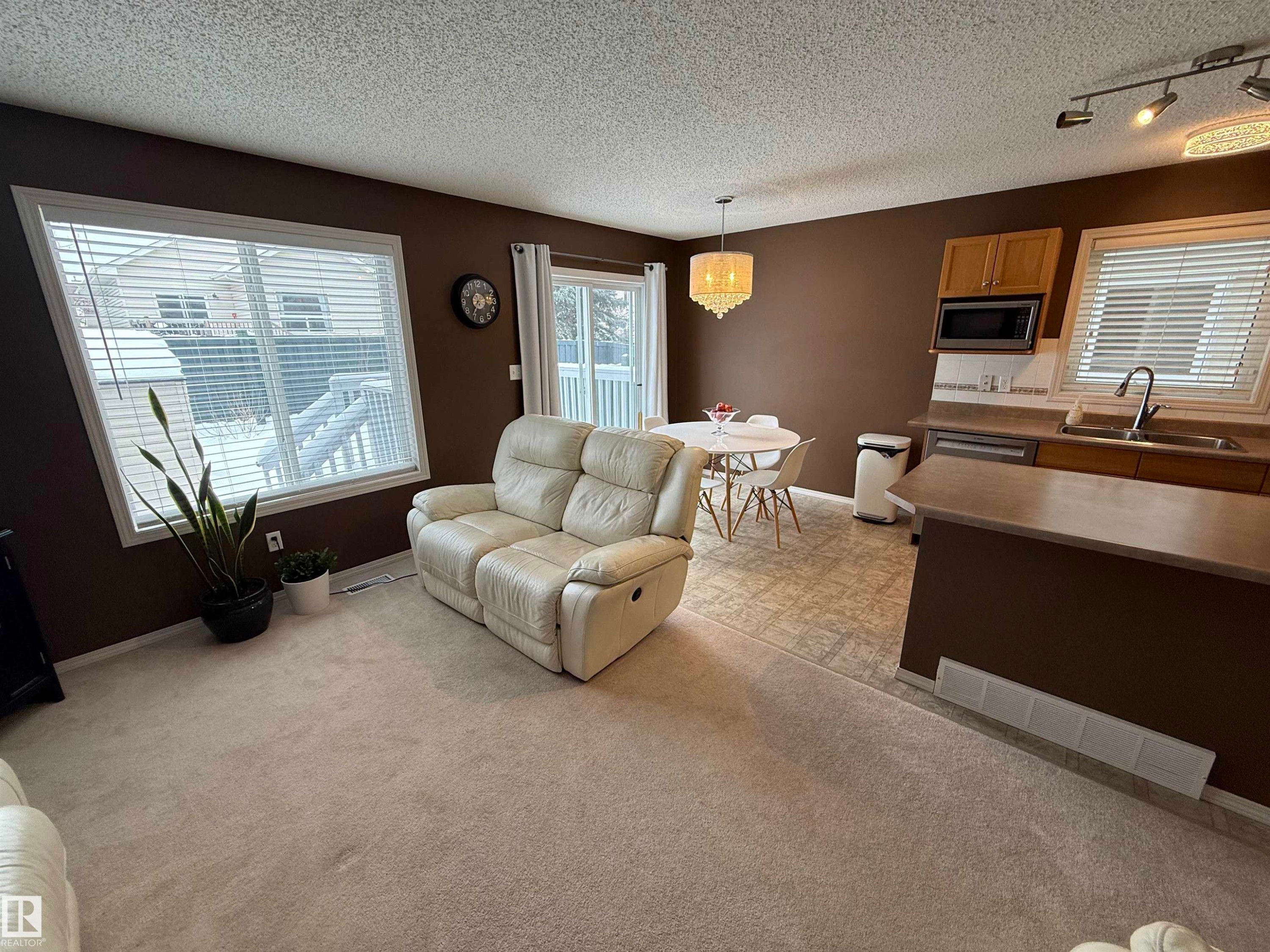 Living area featuring a textured ceiling, light colored carpet, and track lighting - 19 2021 Grantham Crest, Edmonton, AB - Indoor