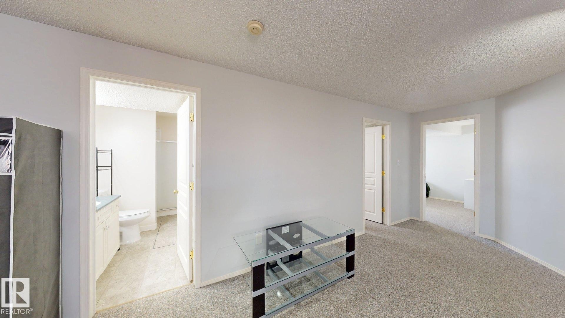Hall with light carpet and a textured ceiling - 17010 84 Street, Edmonton, AB - Indoor