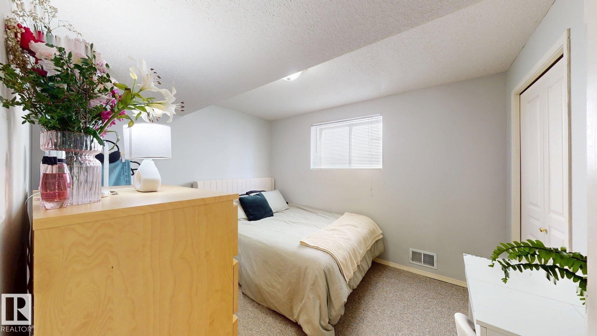 Bedroom with a textured ceiling, light carpet, and a closet - 17010 84 Street, Edmonton, AB - Indoor Photo Showing Bedroom