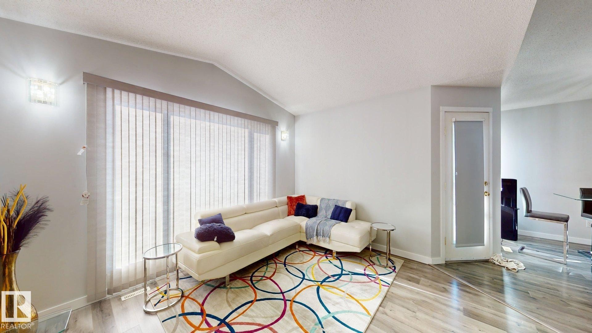 Living room featuring baseboards and light wood-style flooring - 17010 84 Street, Edmonton, AB - Indoor