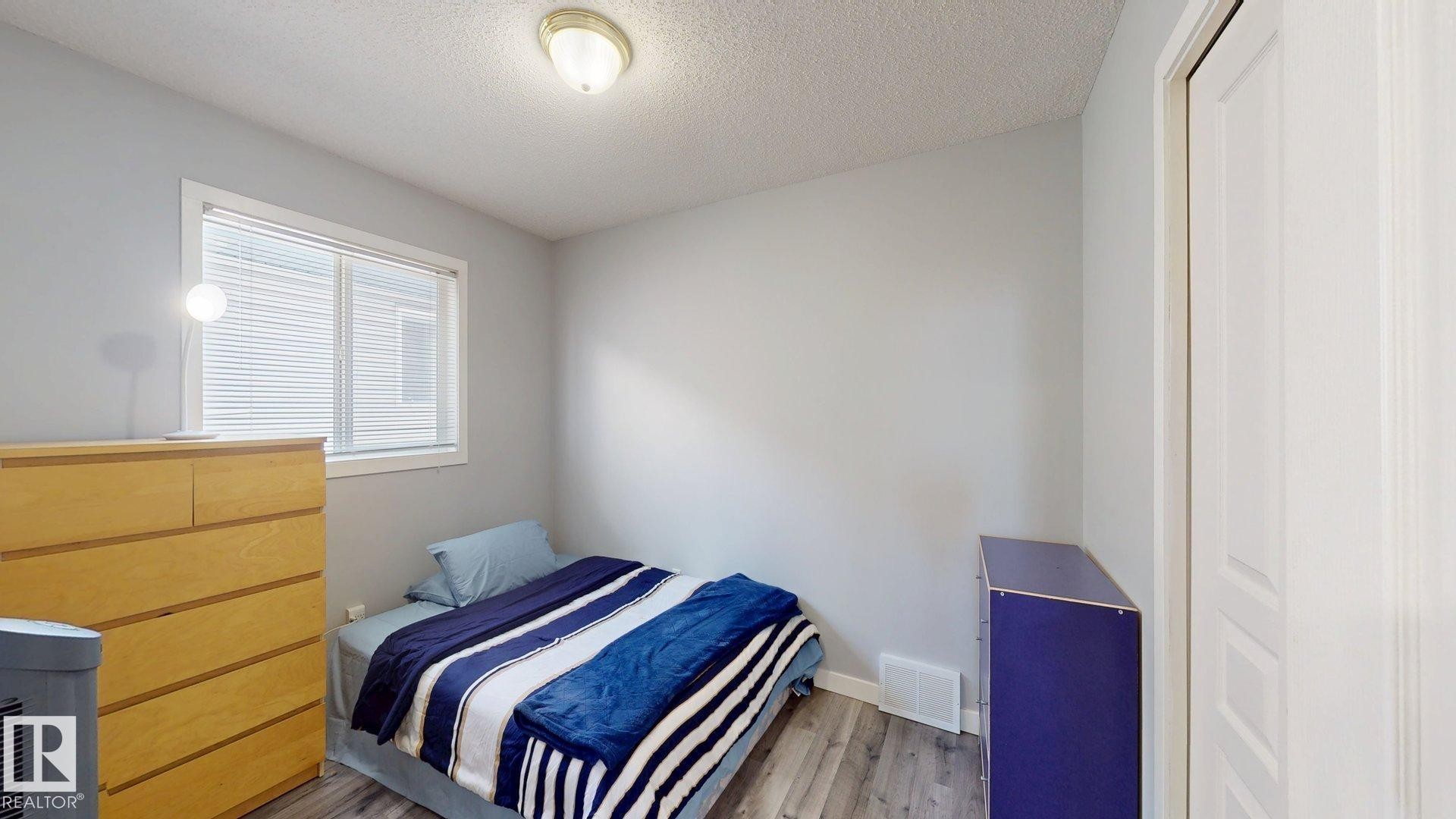 Bedroom featuring light wood-style flooring and a textured ceiling - 17010 84 Street, Edmonton, AB - Indoor Photo Showing Bedroom