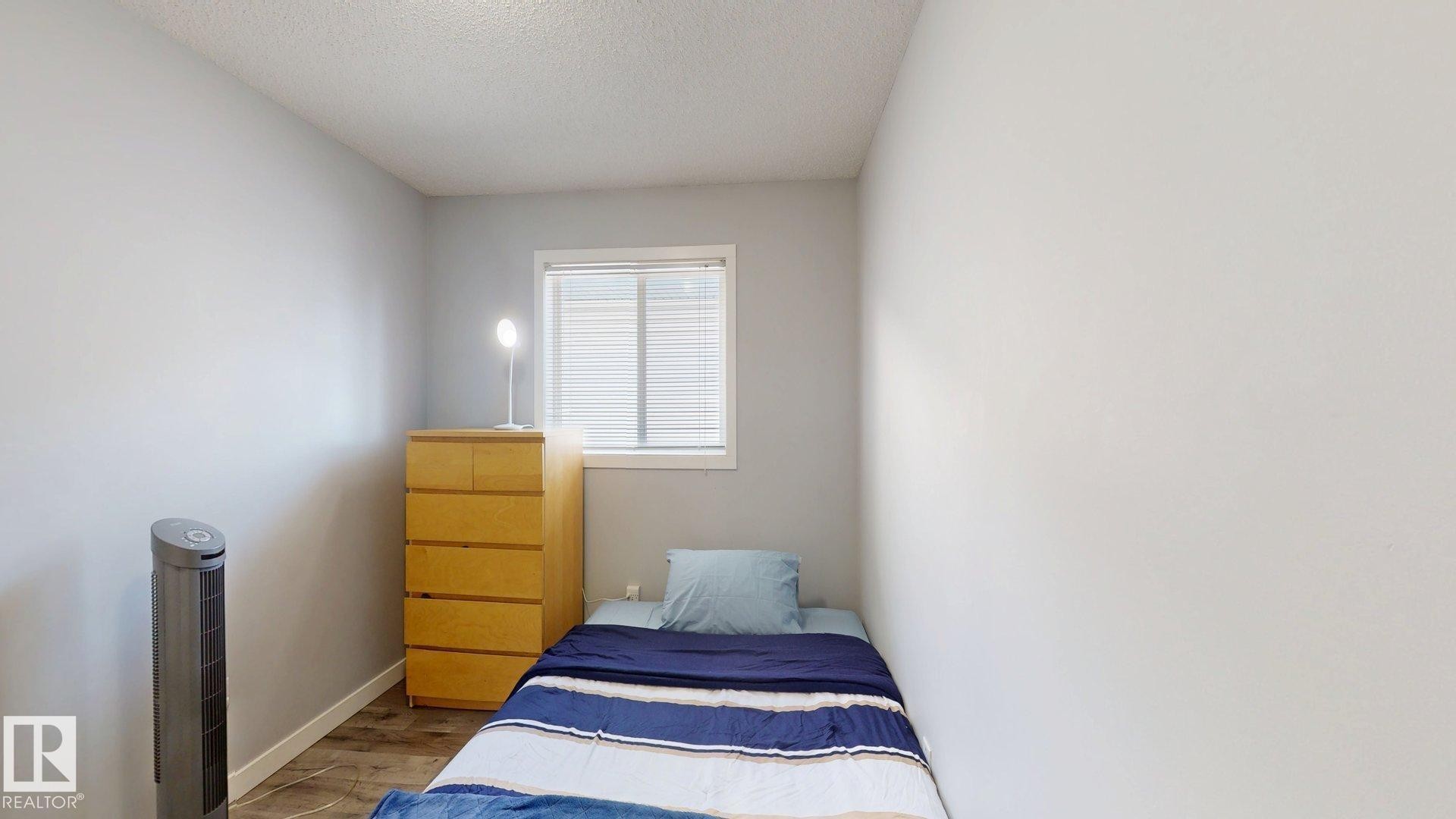Bedroom with wood finished floors and a textured ceiling - 17010 84 Street, Edmonton, AB - Indoor Photo Showing Bedroom