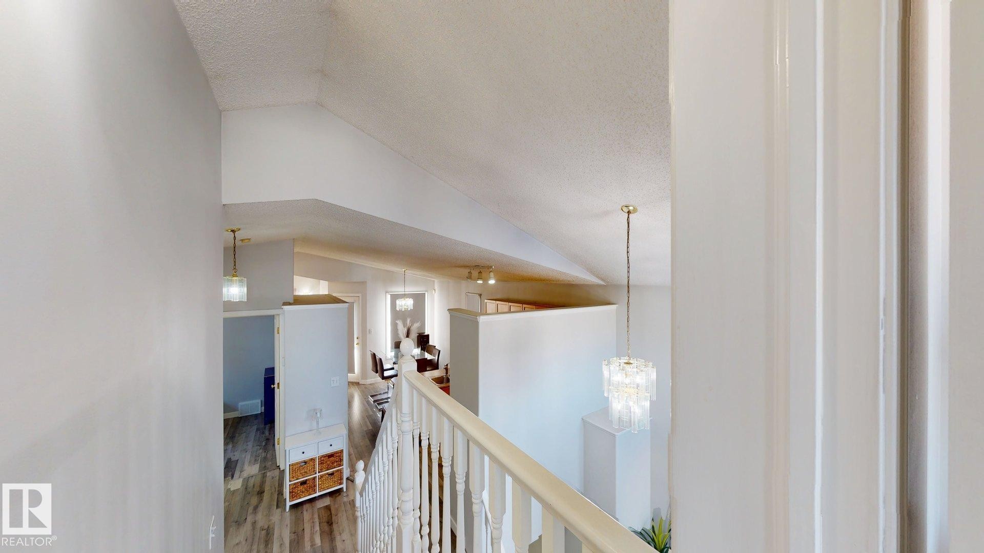 Corridor featuring dark wood-type flooring, an upstairs landing, and a chandelier - 17010 84 Street, Edmonton, AB - Indoor Photo Showing Other Room