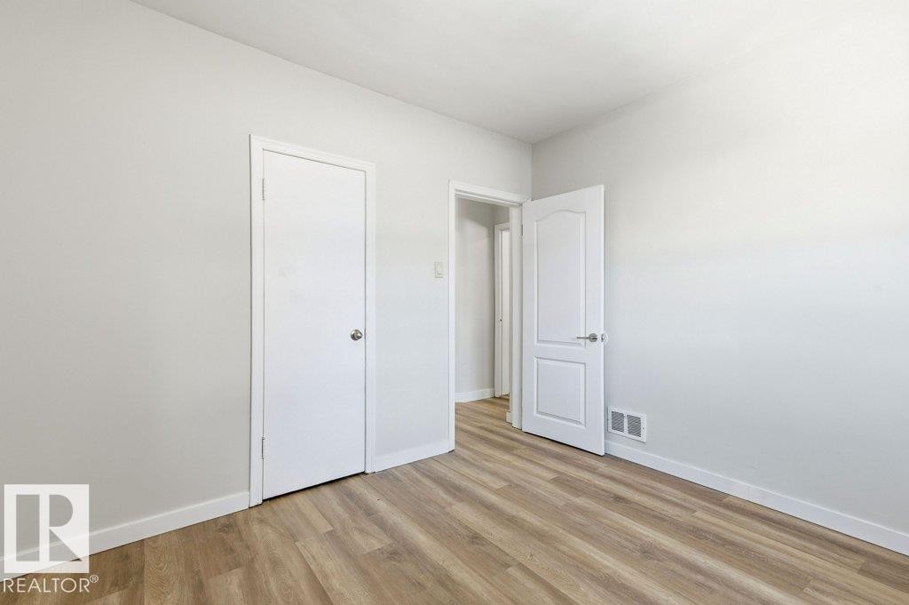 Unfurnished bedroom with light wood finished floors and baseboards - 10704 96 St Nw, Edmonton, AB - Indoor Photo Showing Other Room