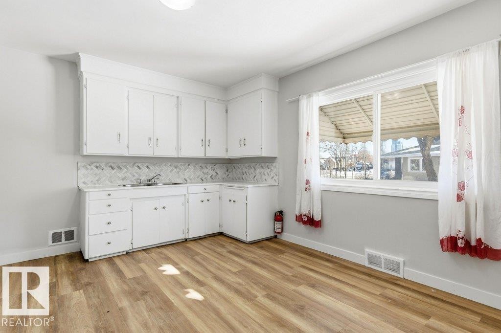 Laundry area featuring light wood-type flooring - 10704 96 St Nw, Edmonton, AB - Indoor Photo Showing Other Room