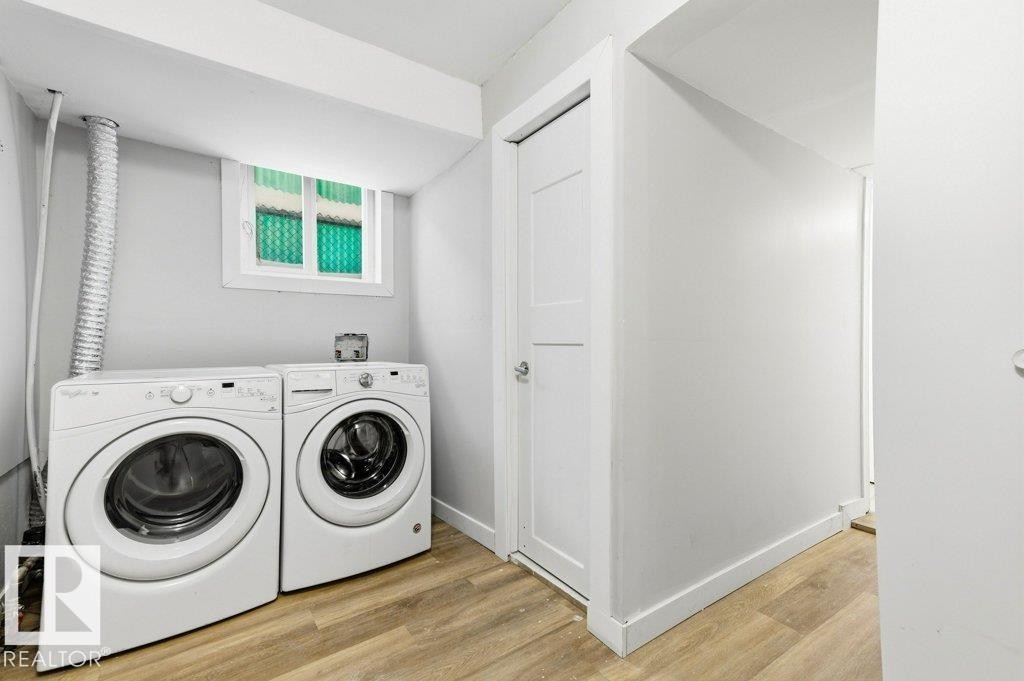 Laundry area with light wood-style floors and washing machine and dryer - 10704 96 St Nw, Edmonton, AB - Indoor Photo Showing Laundry Room