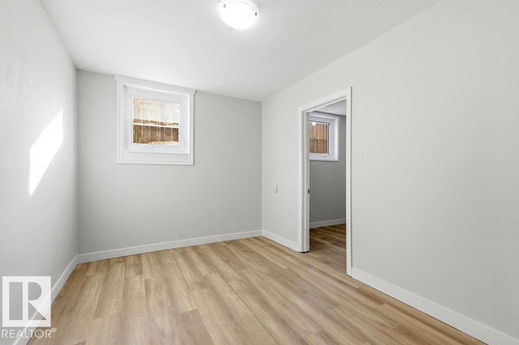 Spare room with light wood-type flooring and baseboards - 10704 96 St Nw, Edmonton, AB - Indoor Photo Showing Other Room