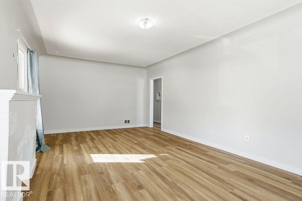 Spare room with light wood-style floors and baseboards - 10704 96 St Nw, Edmonton, AB - Indoor Photo Showing Other Room